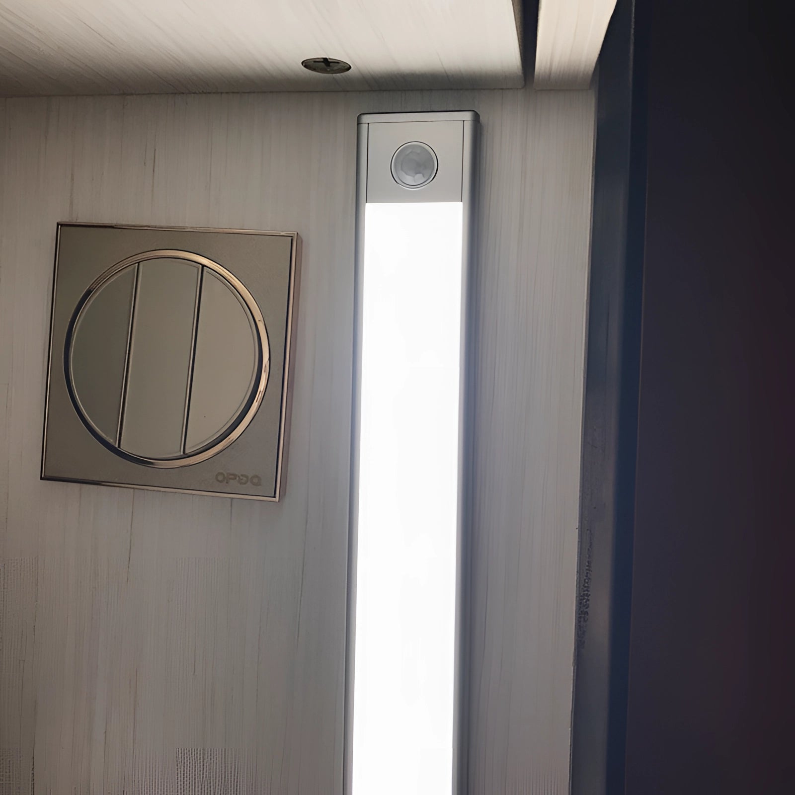 A 12CM magnetic warm white LED strip illuminating a modern kitchen with sleek wooden cabinetry and glass accents.