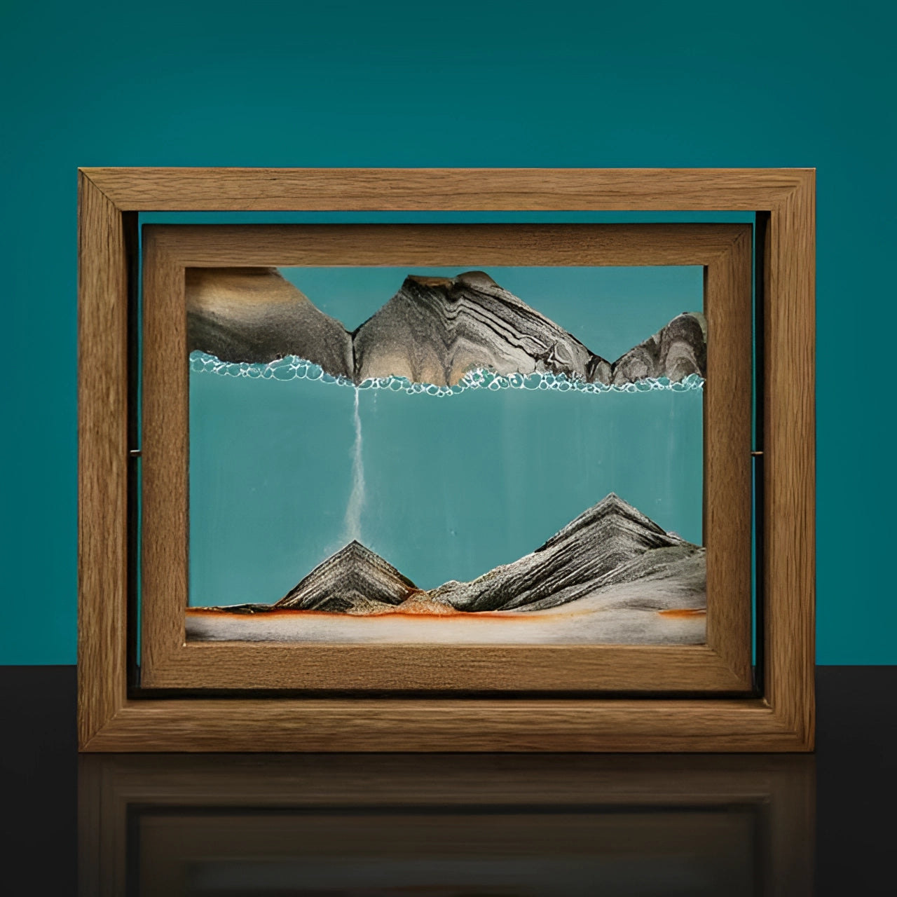 A 3D kinetic sand art picture frame with an aqua blue sand design, housed in a rotating black rectangular frame, displaying a calming landscape effect.
