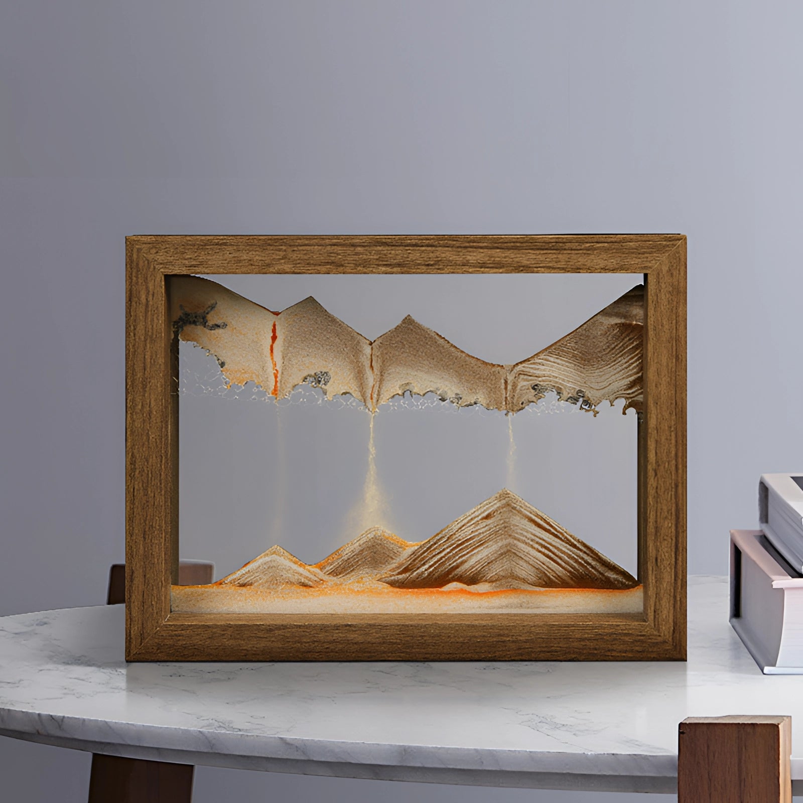 A rectangular 3D kinetic sand art picture frame with aqua blue sand, set in a wooden frame with a natural wood stain finish, displayed on a shelf.
