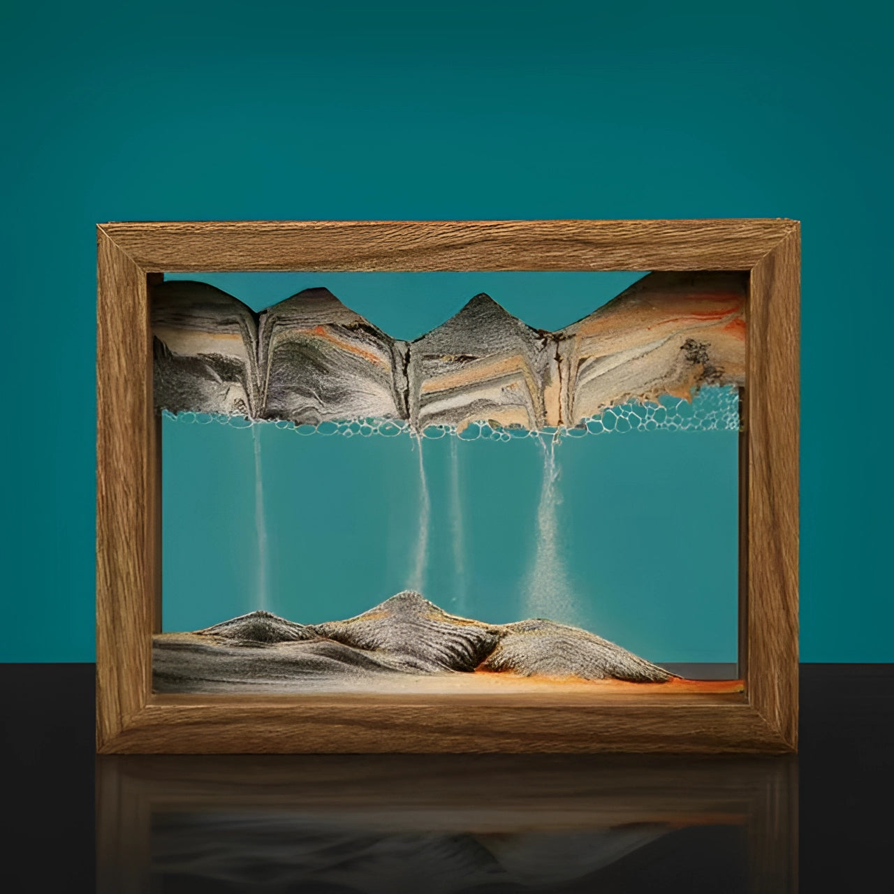 3D kinetic sand art picture frame in aqua blue with a black frame, featuring a rectangular design. The display showcases a dynamic landscape pattern with azure tints and shades, set against a textile-like background. The art piece is symmetrical, resembling a window into a serene landscape.