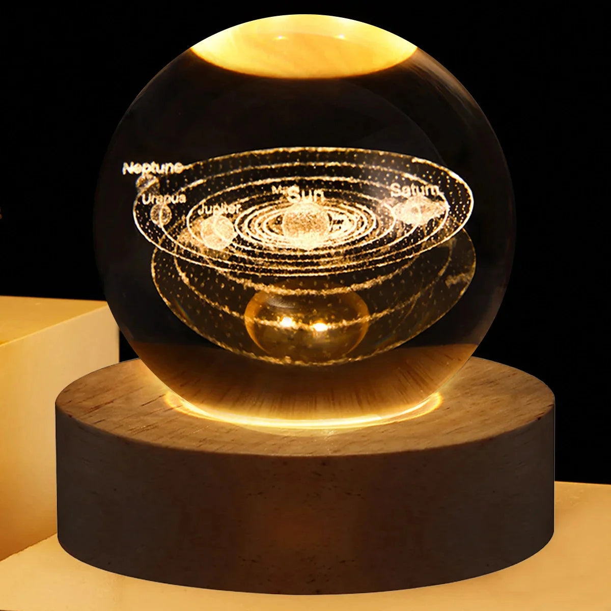 3D crystal ball lamp featuring an intricate solar system design, illuminated by a warm amber LED light on a sleek circular metal base.