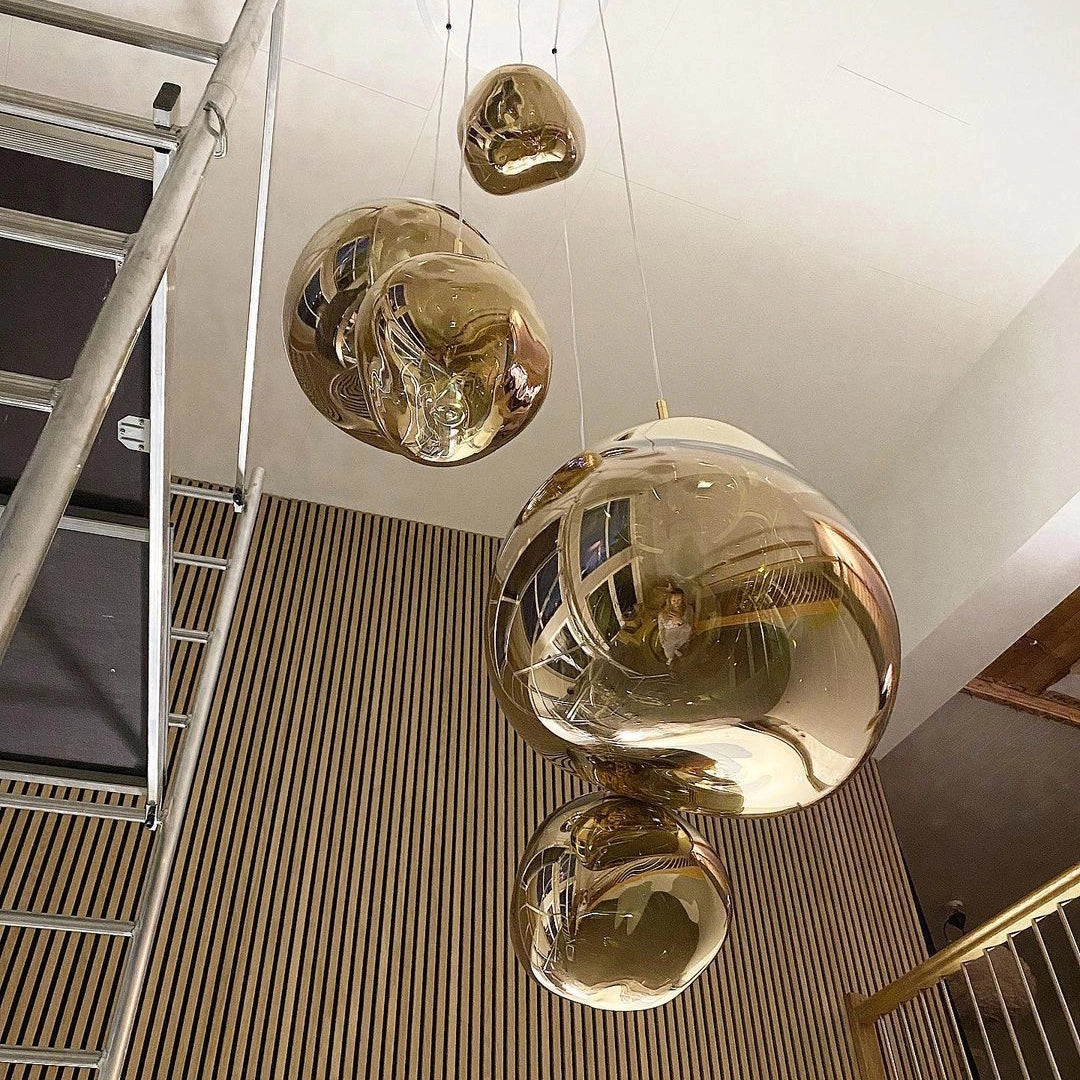 Modern amber glass triple pendant light fixture with copper accents, suspended from the ceiling.