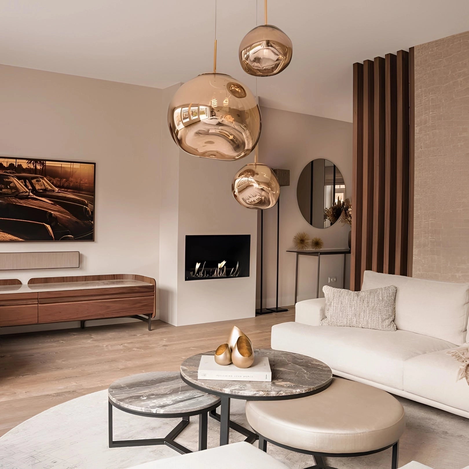 A modern amber glass triple pendant light fixture with a sleek copper finish, hanging from the ceiling, illuminating a stylish interior space featuring wooden furniture and a comfortable couch.