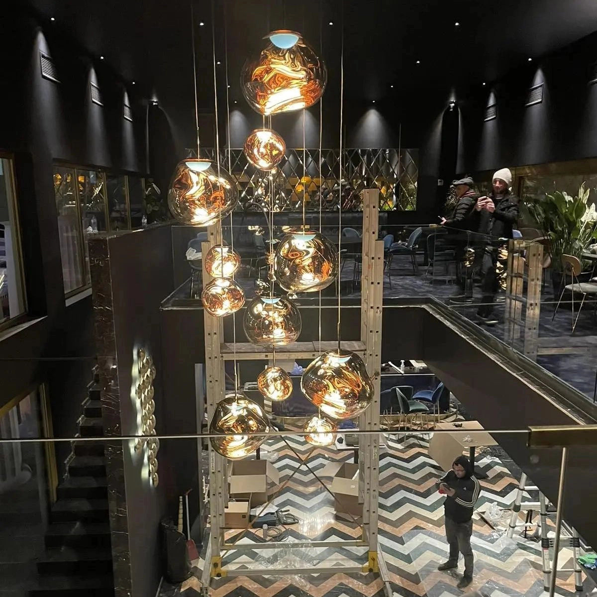 Modern copper ceiling lamp with three amber glass pendants, stylishly hanging in a contemporary interior setting.