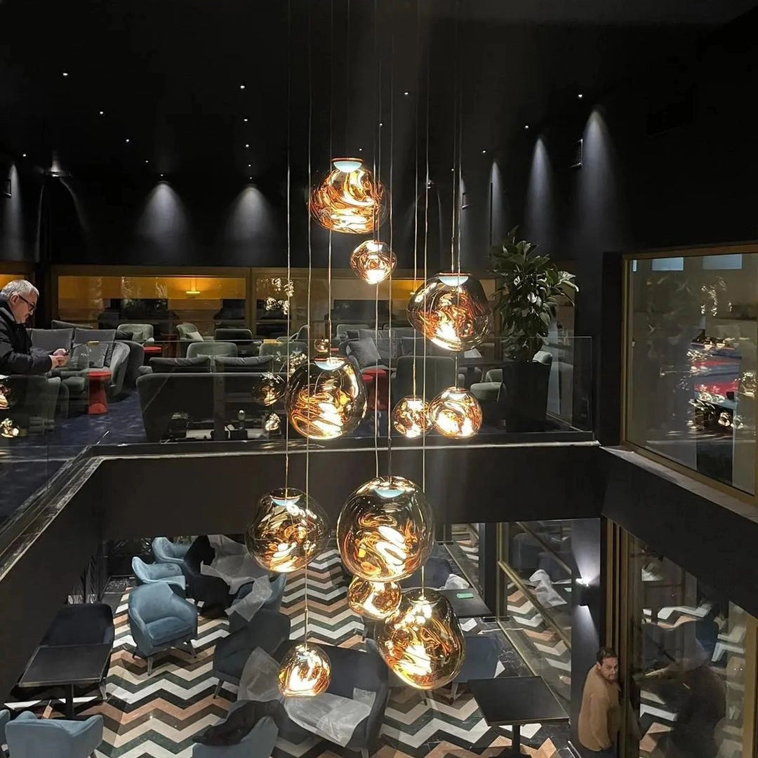 Amber glass triple pendant light fixture with a modern copper finish, showcasing three elegant drop lights suspended from a ceiling mount, suitable for contemporary interior design.