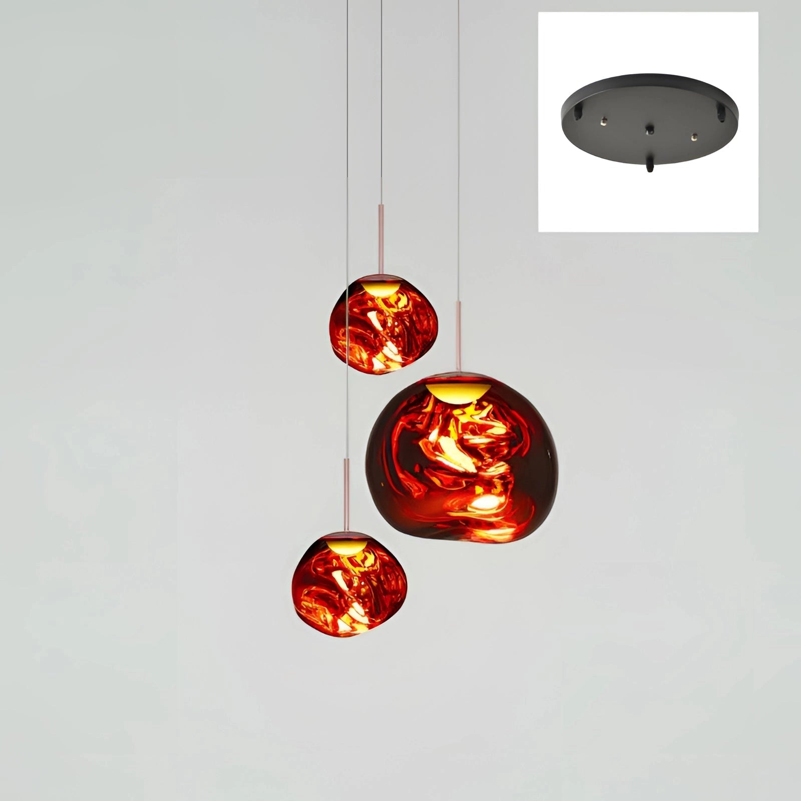 Amber glass triple pendant light fixture with a modern copper finish, featuring three red circular heads of varying sizes, designed for ceiling installation.