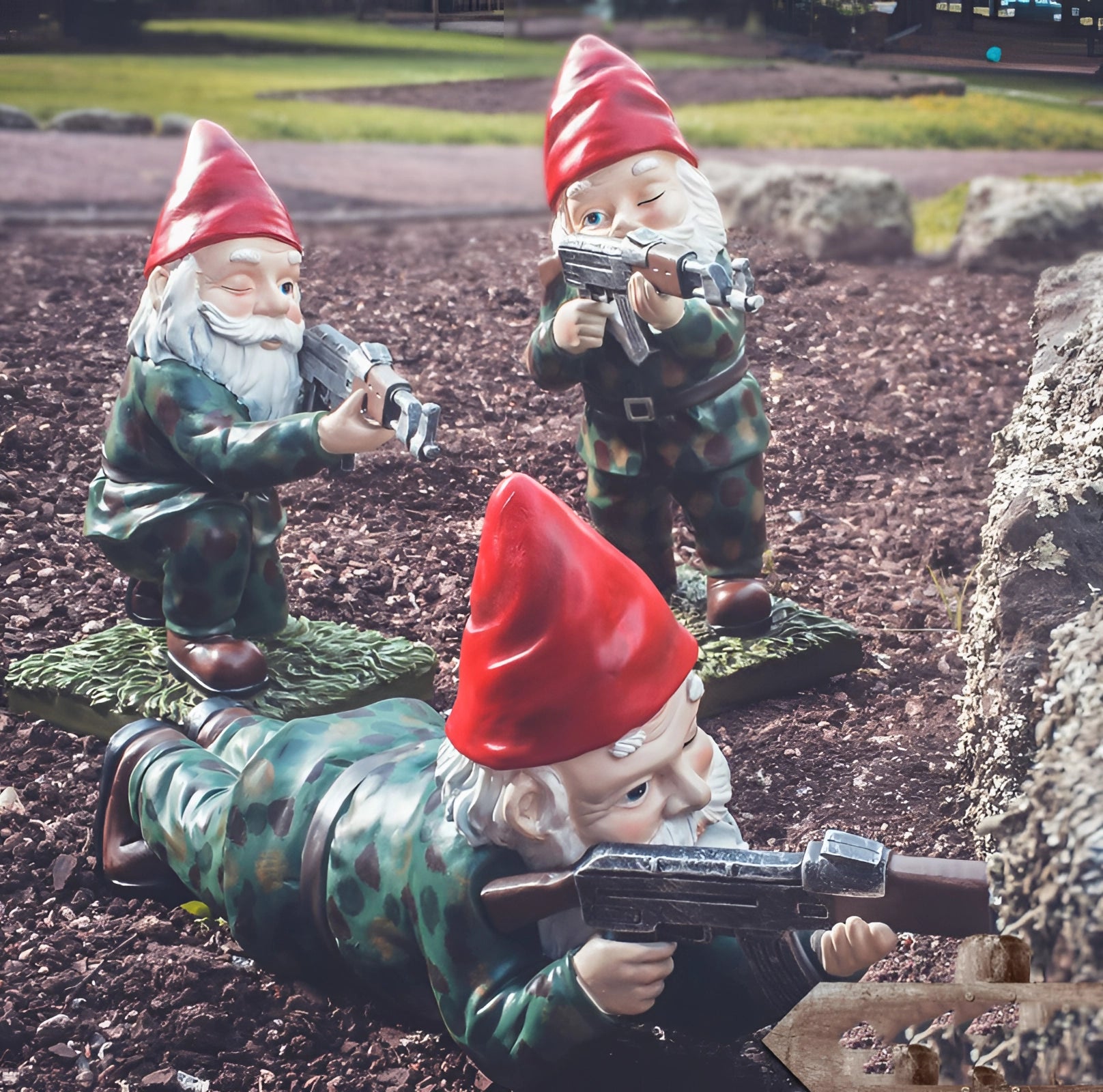 Armed warrior garden gnome statue dressed in military camouflage, wearing a green and red hat, and holding an AK-47 while standing on grass, representing military decor.