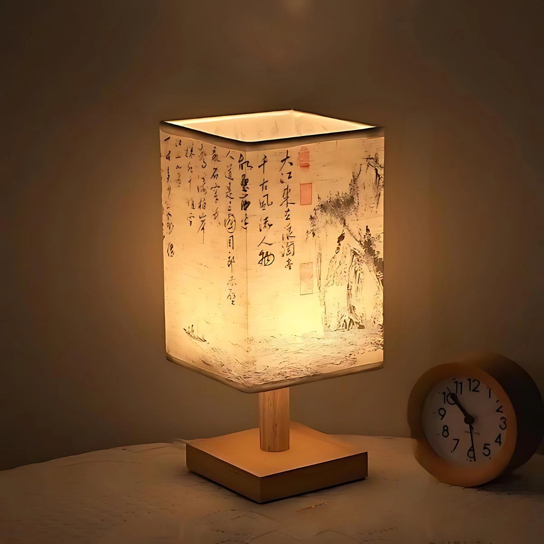 Asian-inspired wooden table lamp with a parchment lampshade featuring a warm amber glow, showcasing a cylindrical design with artistic elements.