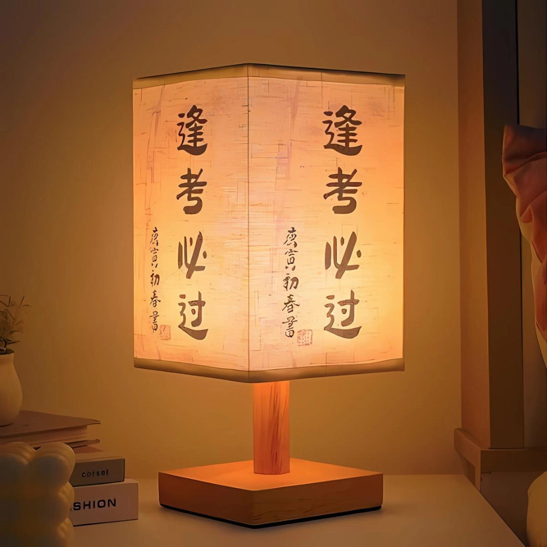 Asian-inspired wooden table lamp with a parchment lampshade, featuring artistic design elements and surrounded by decorative houseplants.