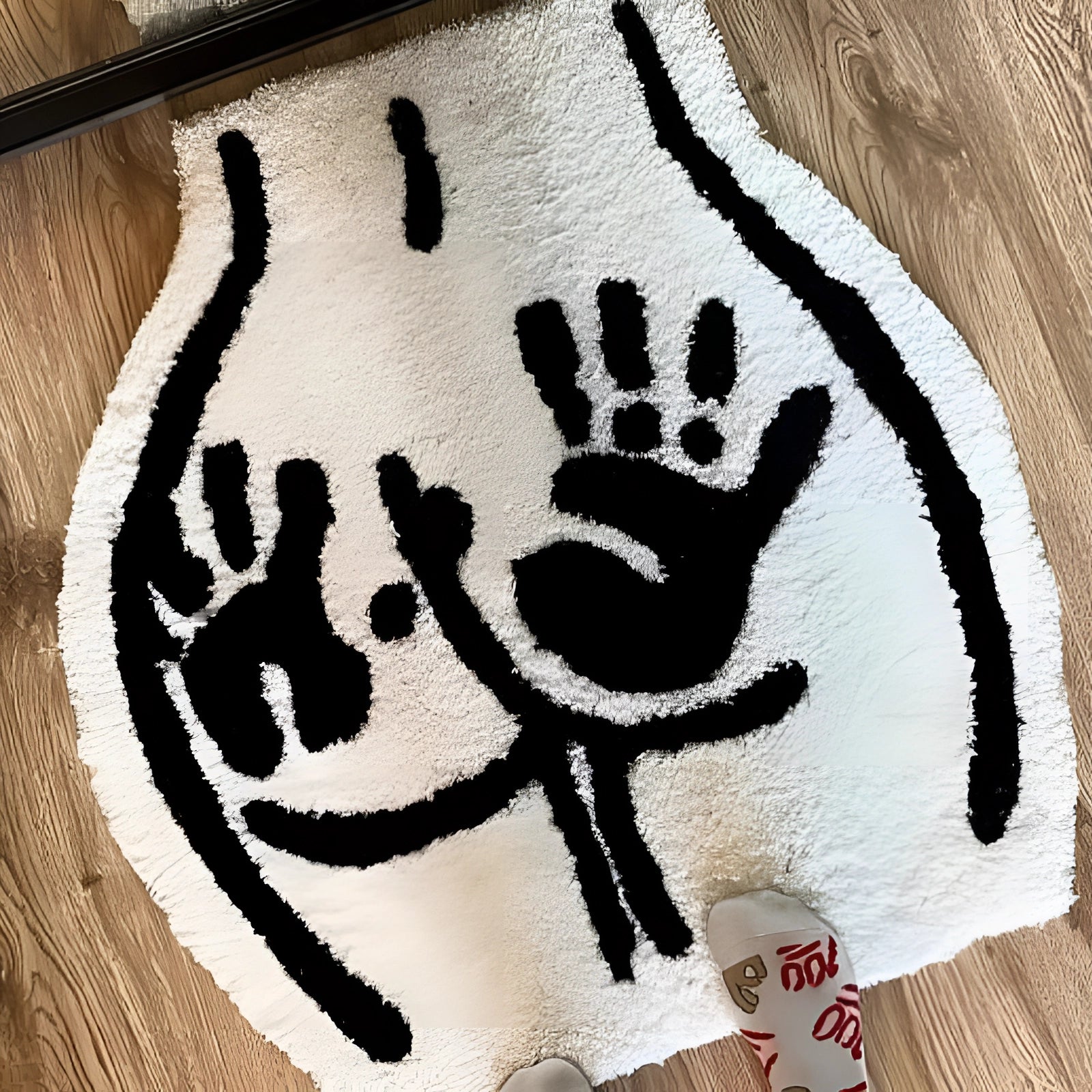 Bear paw print rug featuring a wildlife-inspired design, measuring 60x55 cm. The rug showcases an artistic pattern of a mammal's footprint, resembling a stencil or ink art, set against a wood-like background, creating a rustic and natural aesthetic.