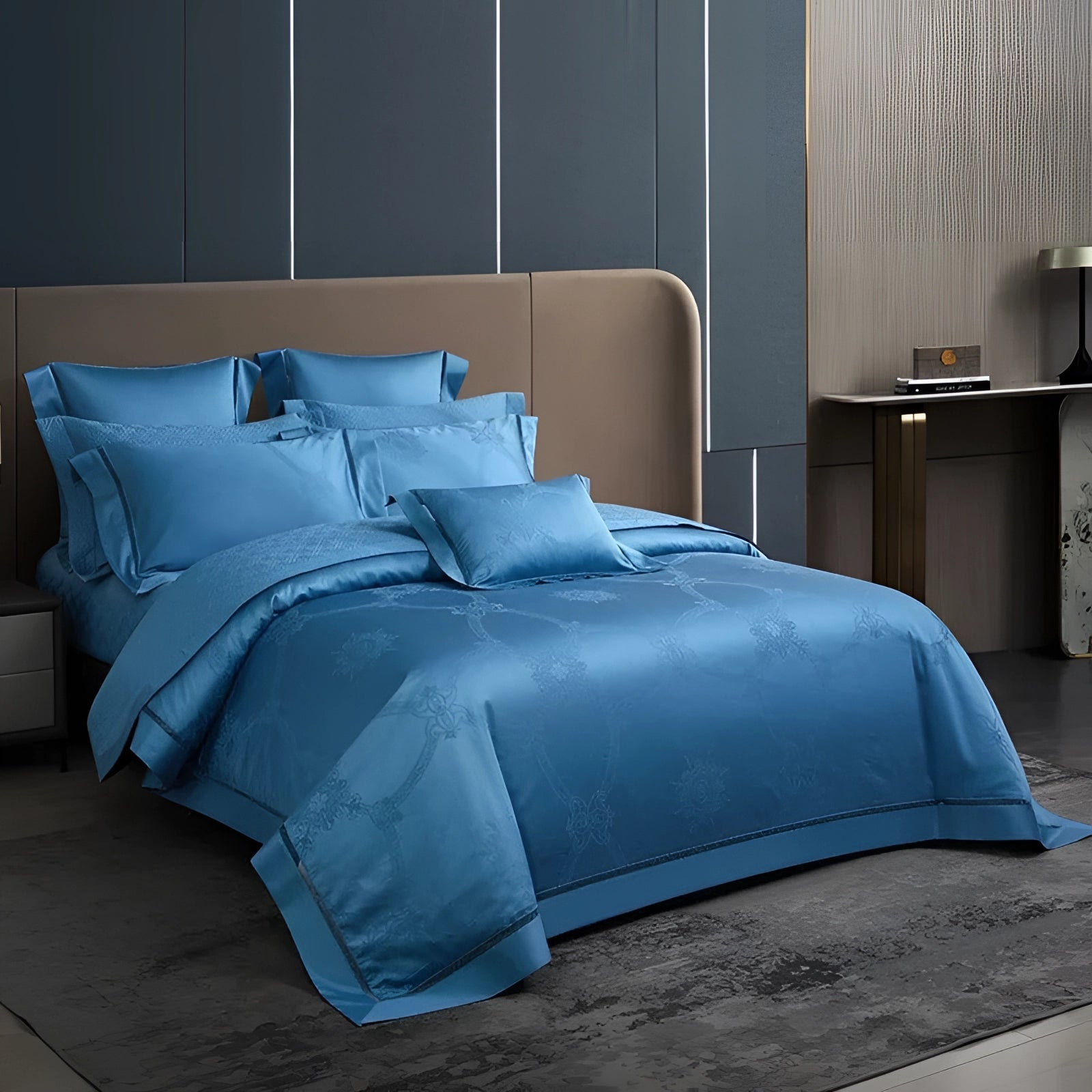 Blue king size silk bedsheet set with a luxurious and wrinkle-free finish on an American king bed, featuring coordinating azure pillows and a grey wooden bed frame, accompanied by a sleek lamp for added comfort and elegance.