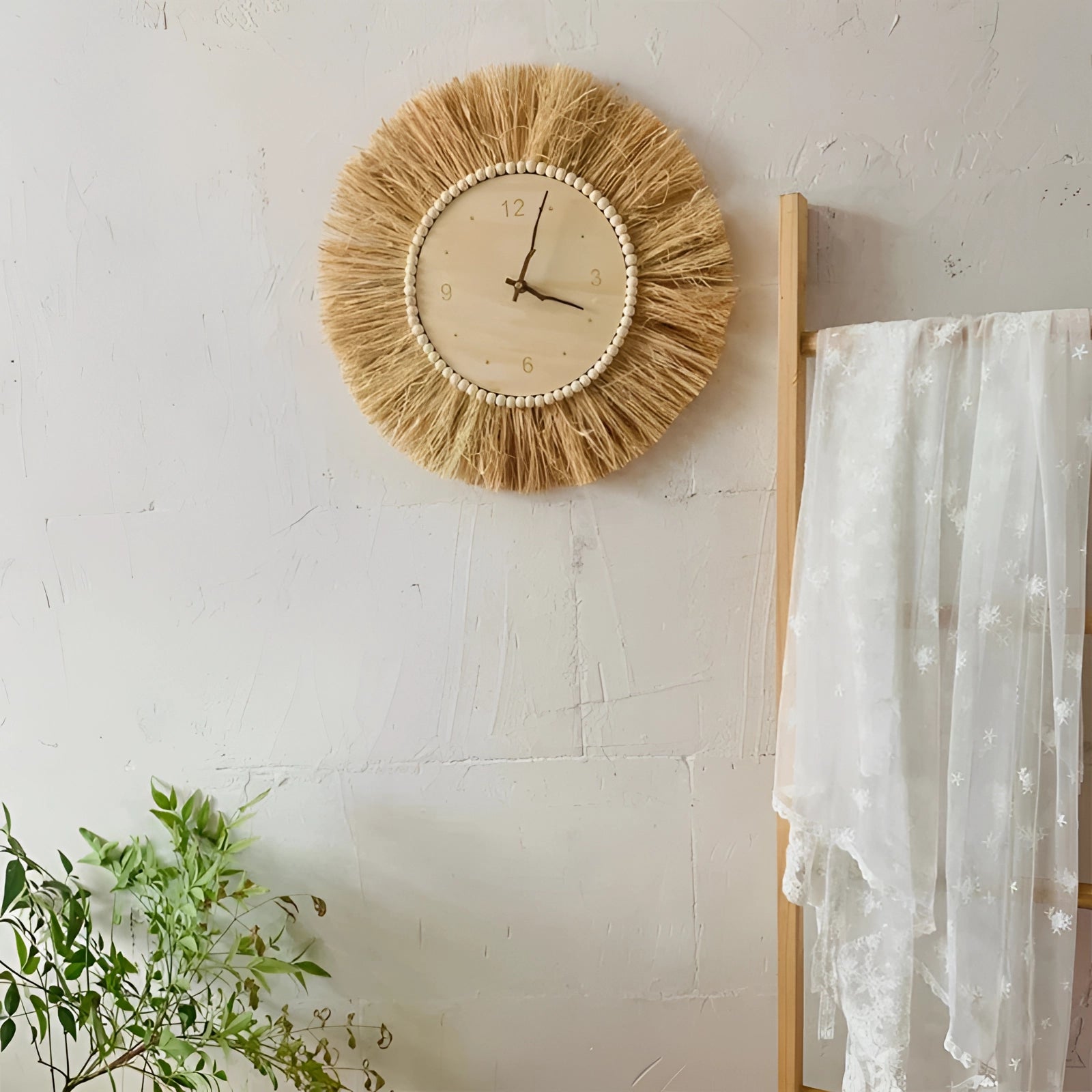 A boho tassel wall clock with a handcrafted fringe design, featuring a circular clock face mounted on a rectangular wooden backing, adorned with tassels. The clock is styled with natural elements, including twig-like accents, and is set against an interior background.
