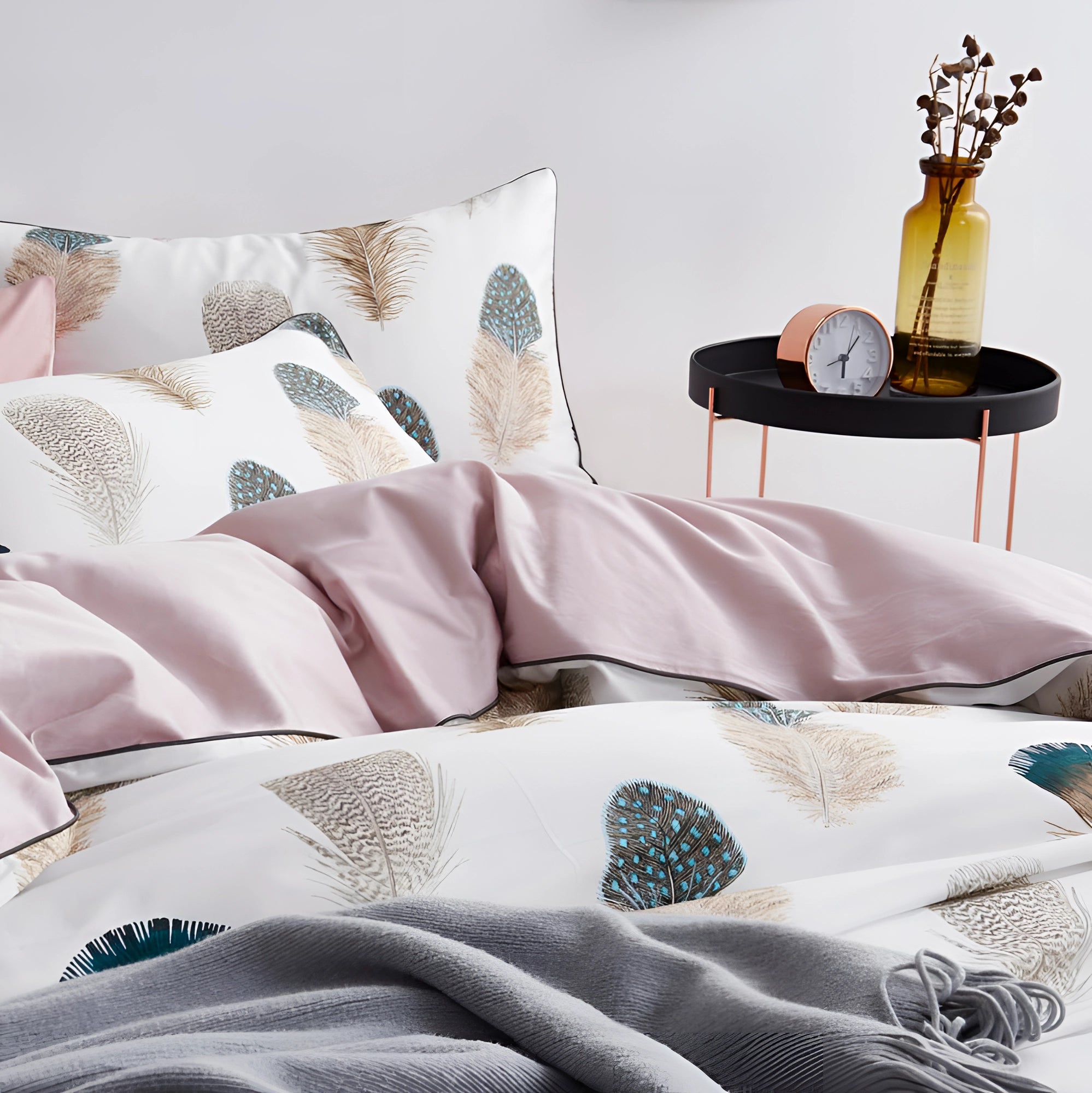 Pink and white botanical print feather pattern duvet set displayed on a king-size bed in a modern interior setting, with matching pillows and a cozy ambiance.