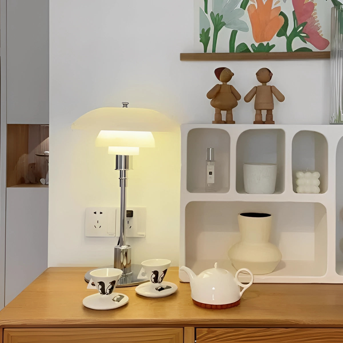 A brass table lamp with an opal glass shade on a wooden shelf in a minimalist interior setting.