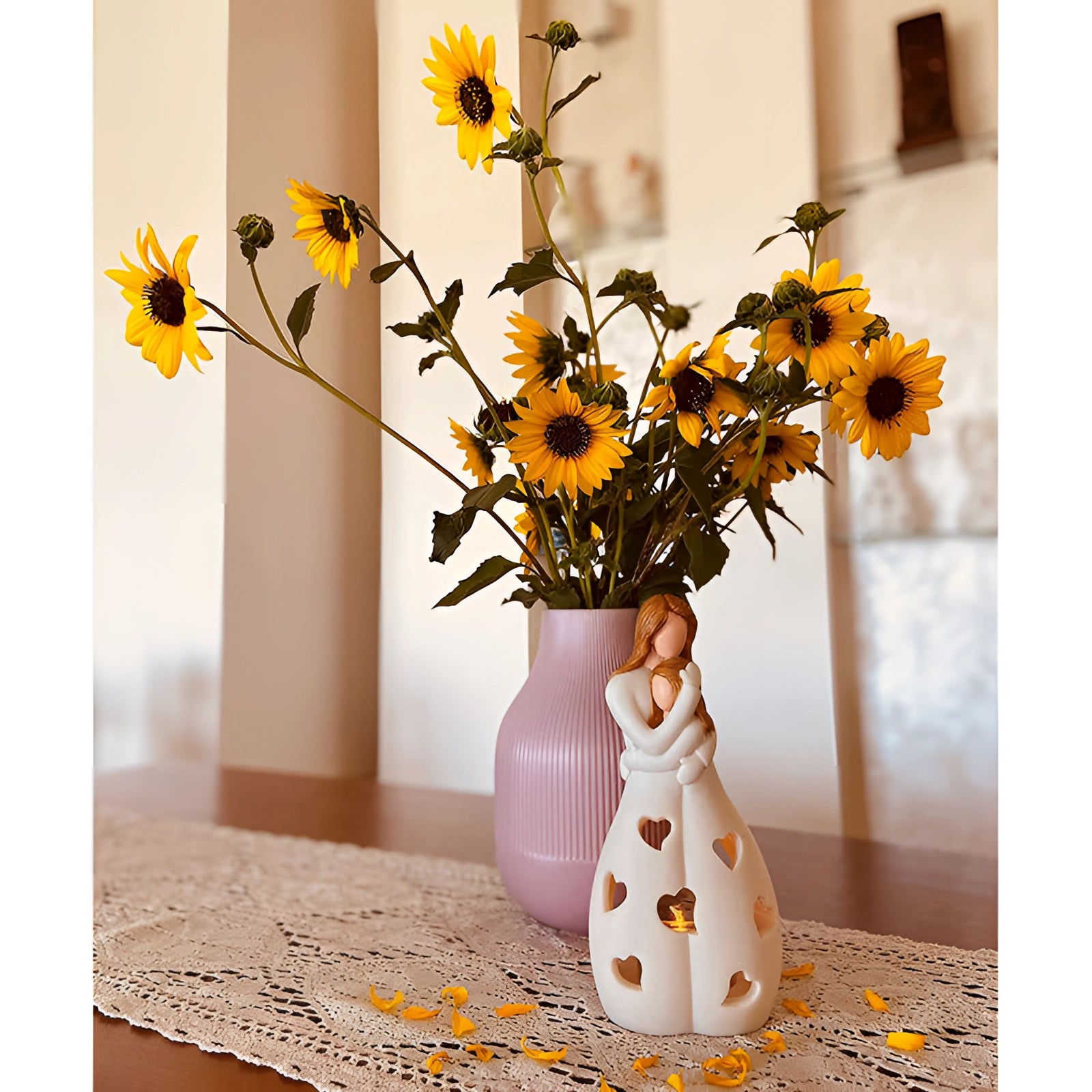 Ceramic lamp with heart pattern design emitting a warm, romantic glow, surrounded by orange and yellow flowers in vases, creating a cozy and inviting atmosphere.