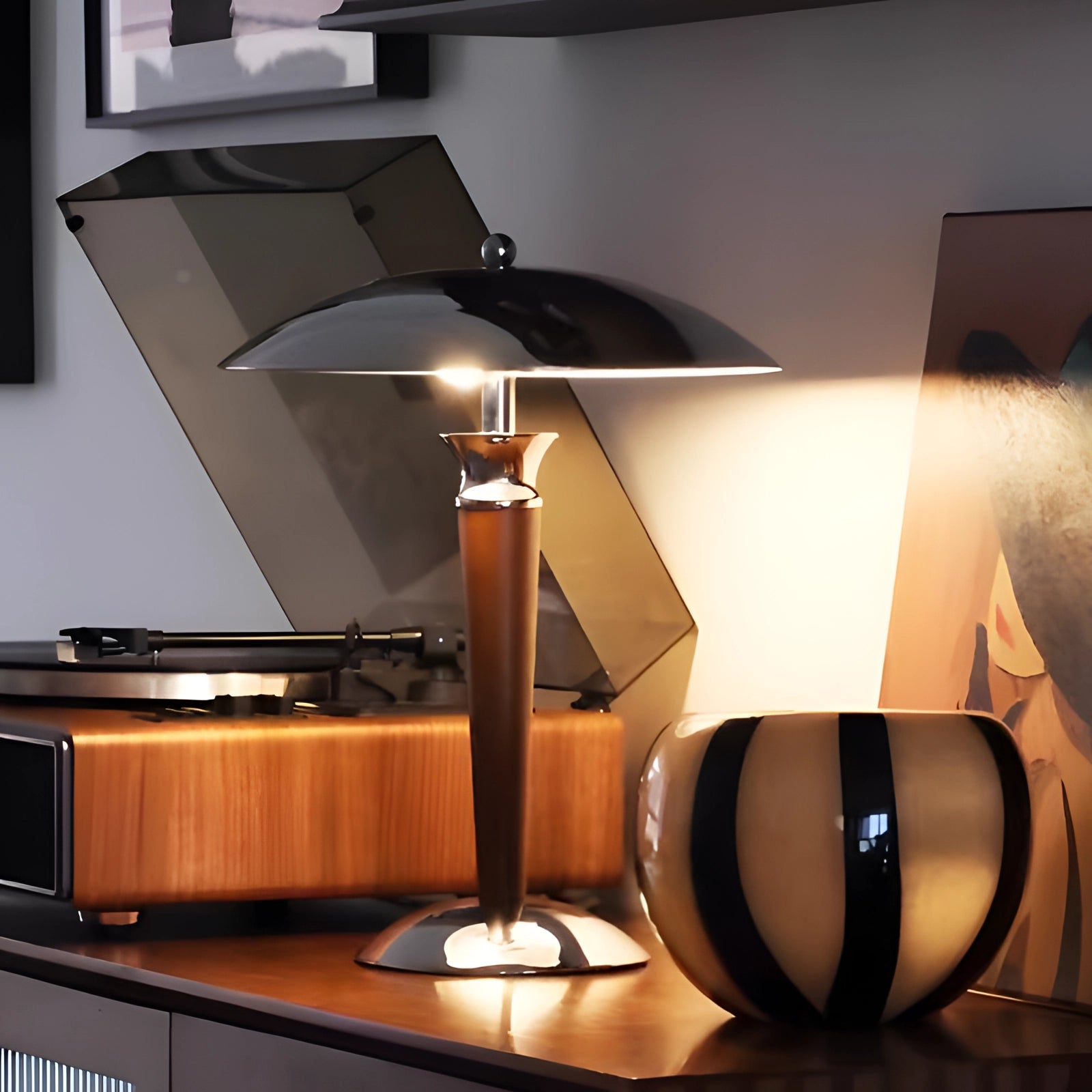 A modern and elegant chrome finish metal table lamp with an adjustable dimmer, placed on a wooden surface, illuminating an interior space with its sleek design.