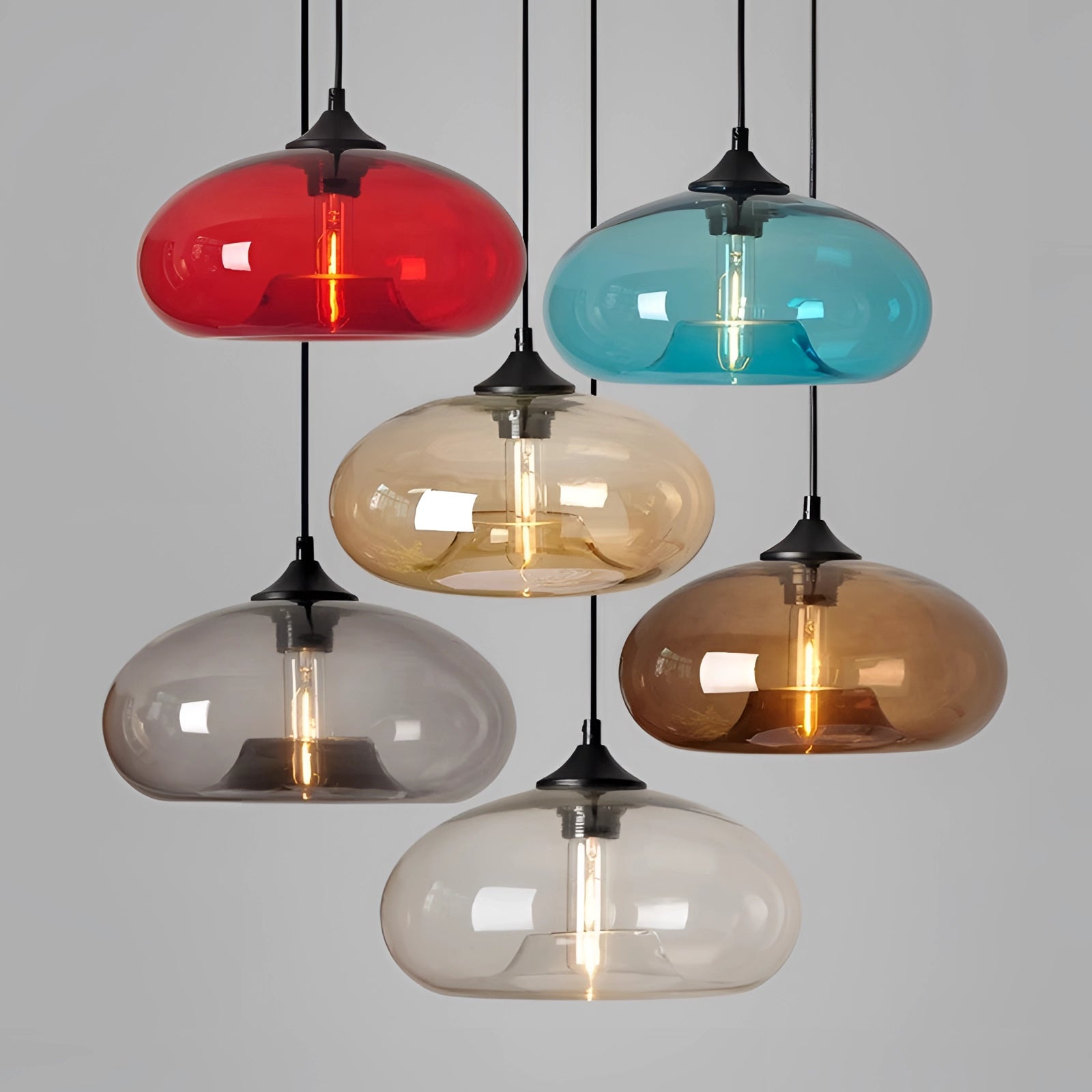 Colorful glass pendant lights with modern mid-century design, featuring circular shapes and natural wood accents, illuminating with warm tints and shades.
