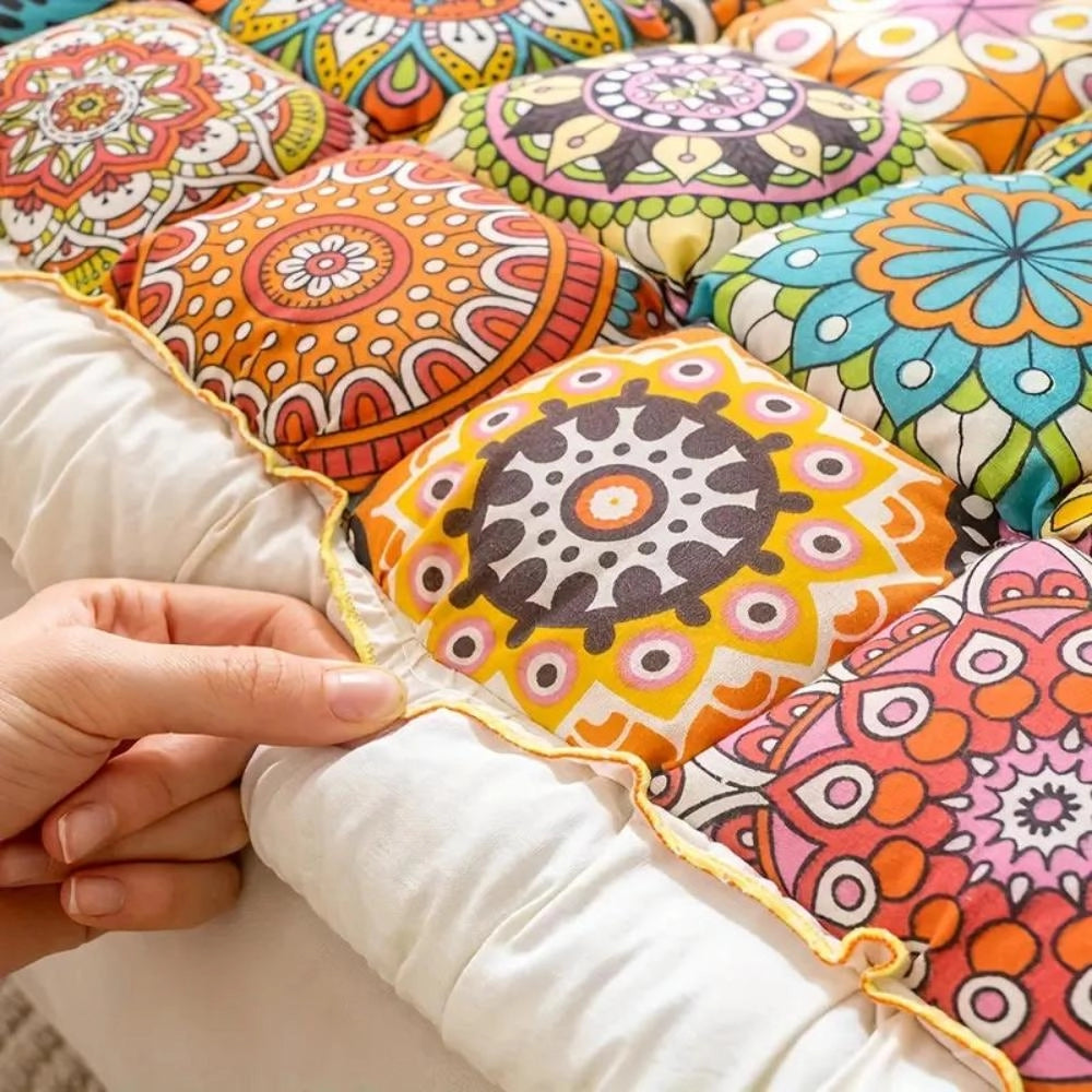 Colorful mandala bohemian throw pillows with intricate patterns and motifs, perfect for adding unique artistic flair to a living room decor. The design features vibrant orange hues and is complemented by surrounding plant elements for a harmonious visual appeal.