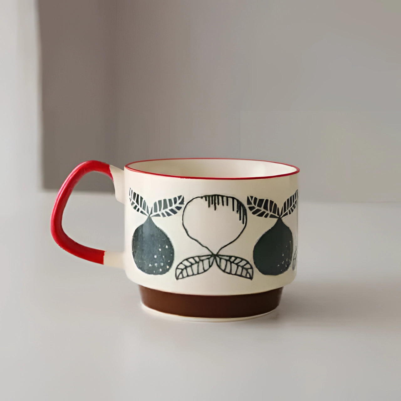 Colorful polka dot ceramic mug with red handle and blue base featuring an apples and pears design, suitable for use as coffee cup or teacup.