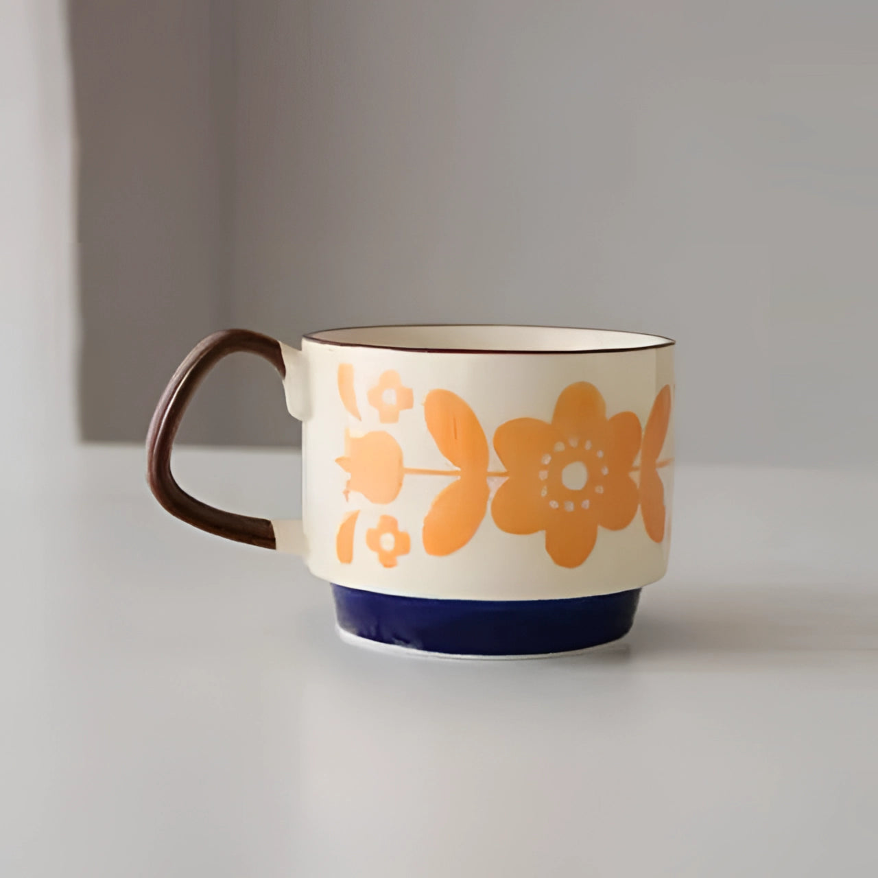Colorful polka dot ceramic mug with a red handle and blue base, featuring a yellow flower design.