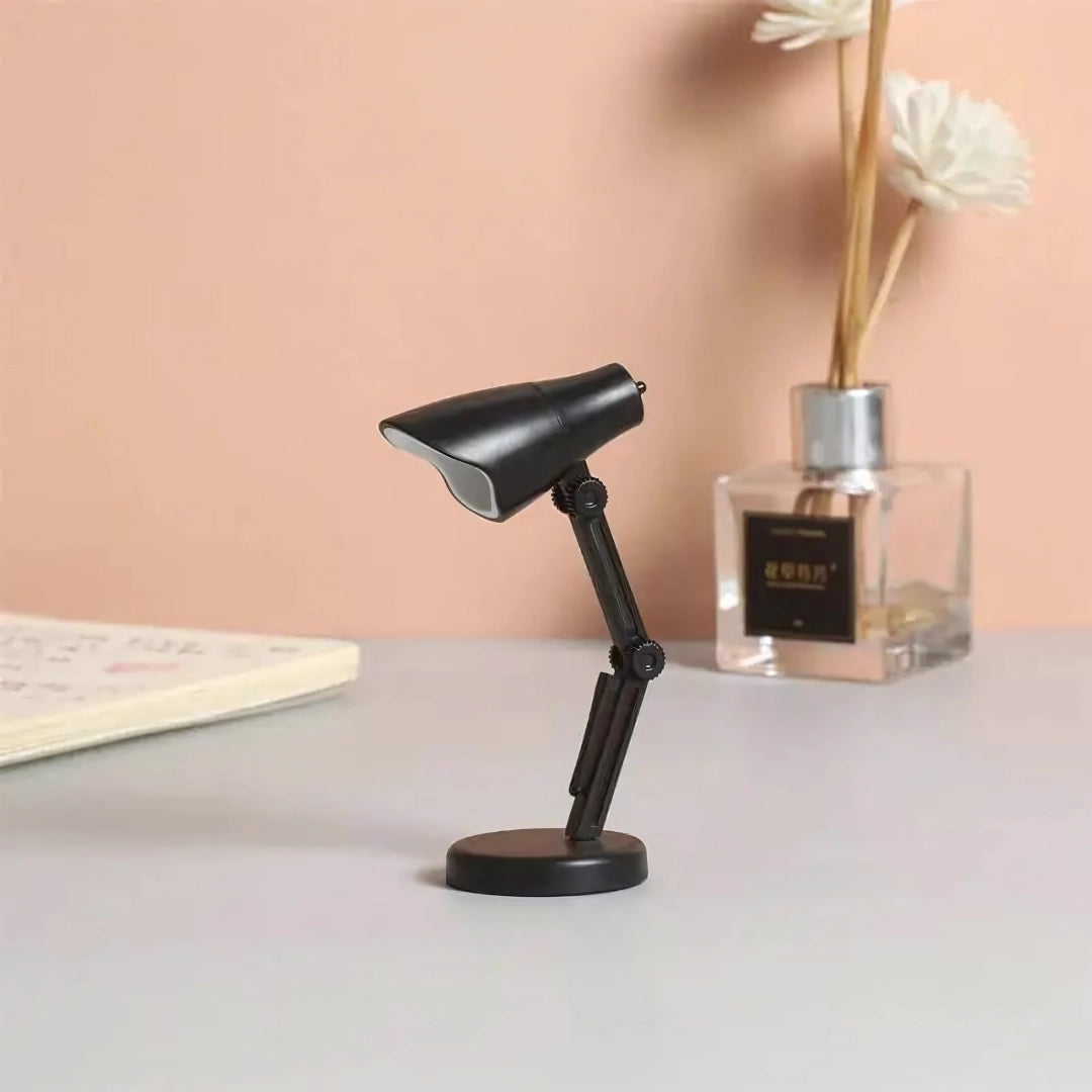 Black Coral Mini LED Adjustable Desk Lamp with a stylish design, featuring a sleek metal and wood construction, suitable for office or home lighting, set against a hardwood floor background.