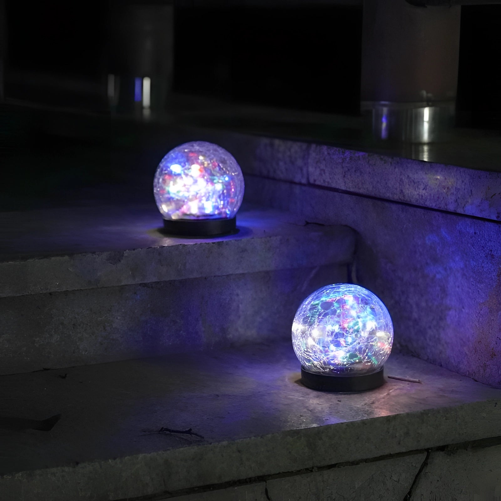 Crackled glass solar light with a purple hue, resembling a globe, illuminated in darkness, showcasing electric blue and other tints and shades.