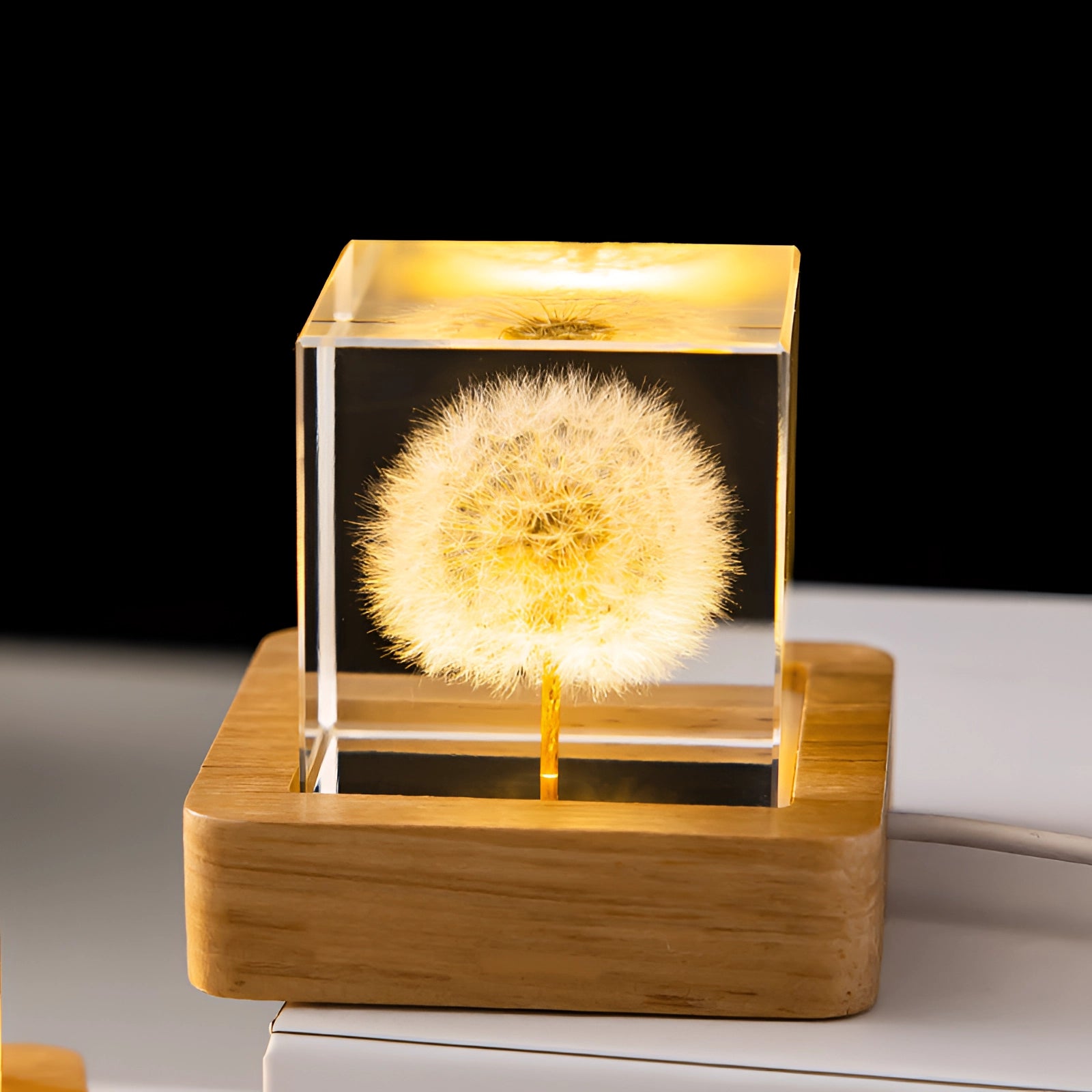 Dandelion Resin Lamp with LED Wooden Base, featuring a square design encapsulating a delicate dandelion, illuminating with soft light.