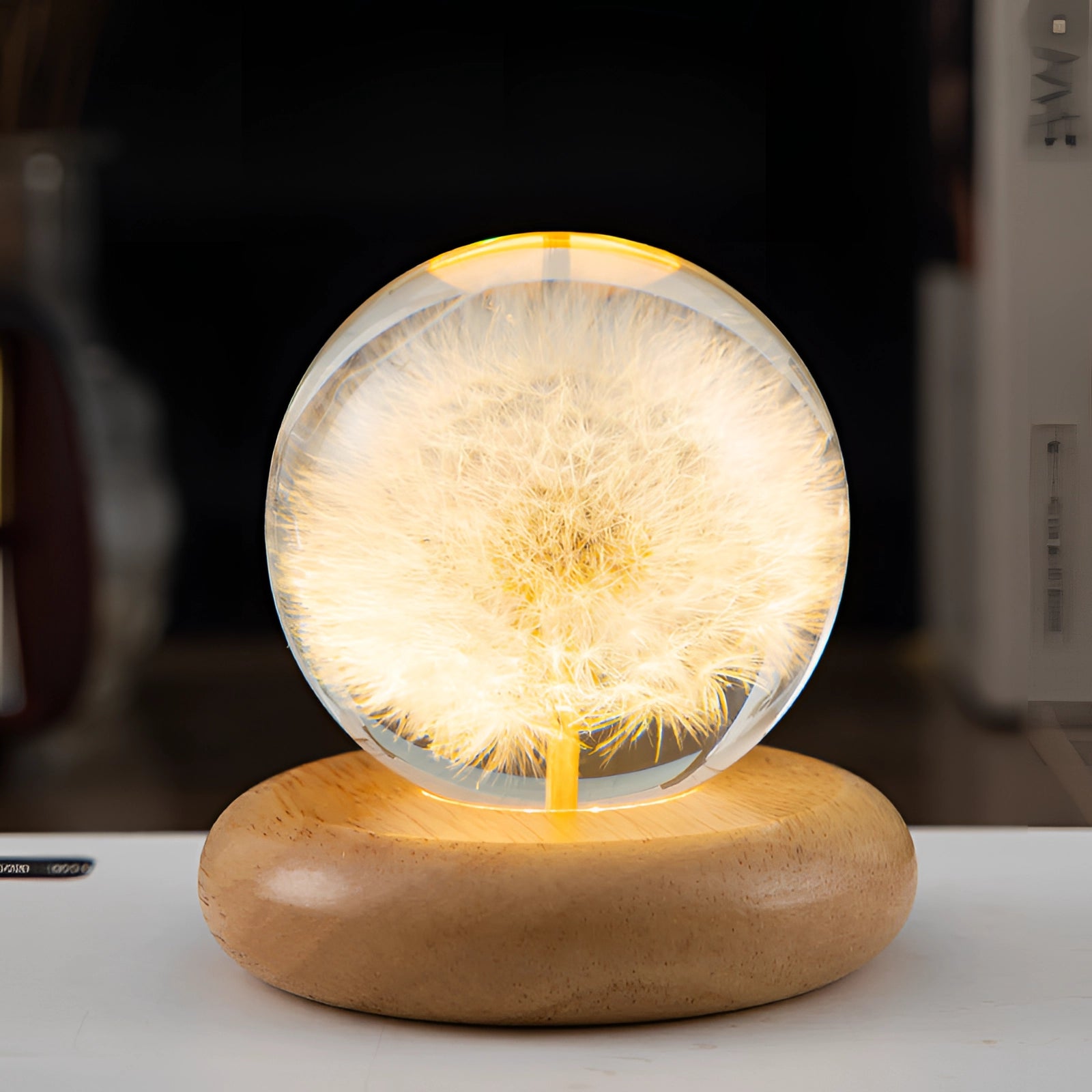 Dandelion Resin Lamp with LED Wooden Base featuring a round dandelion design encased in clear resin, illuminated from below with a warm LED light, creating a unique botanical night light. The lamp sits on a smooth wooden base, highlighting the delicate plant structure within.