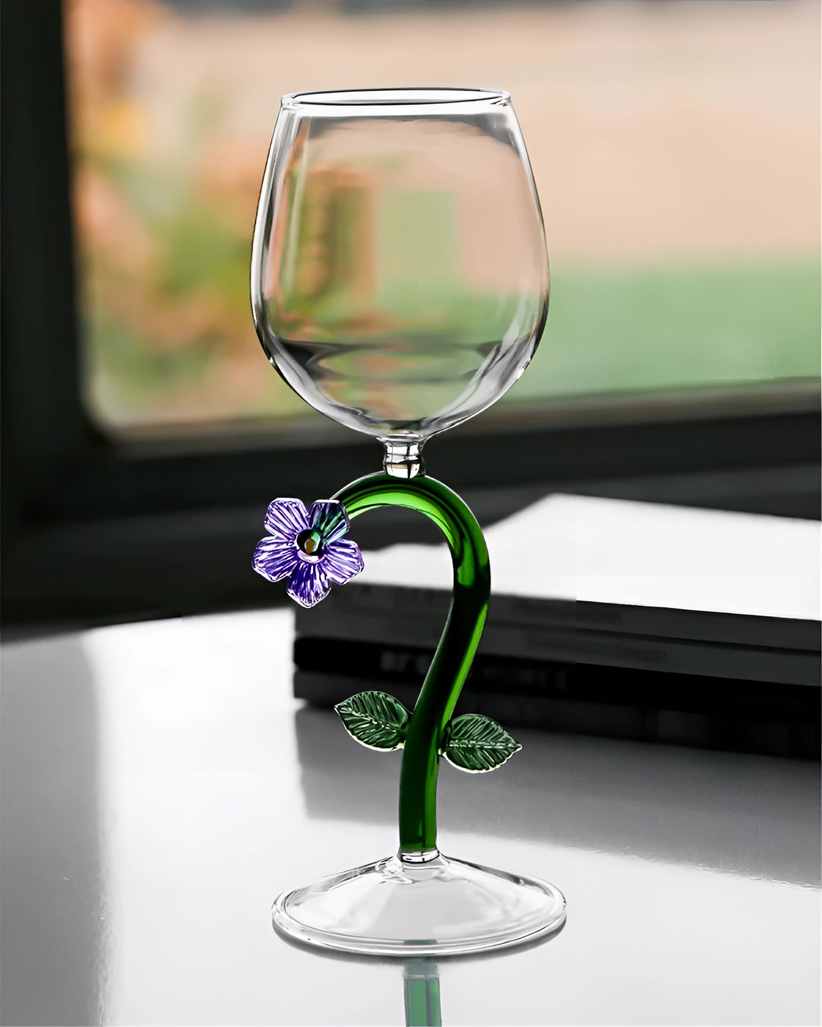 A set of decorative artistic handcrafted vineyard wine glasses on a table, filled with liquid, showcasing intricate green stemware design and artistic elements.