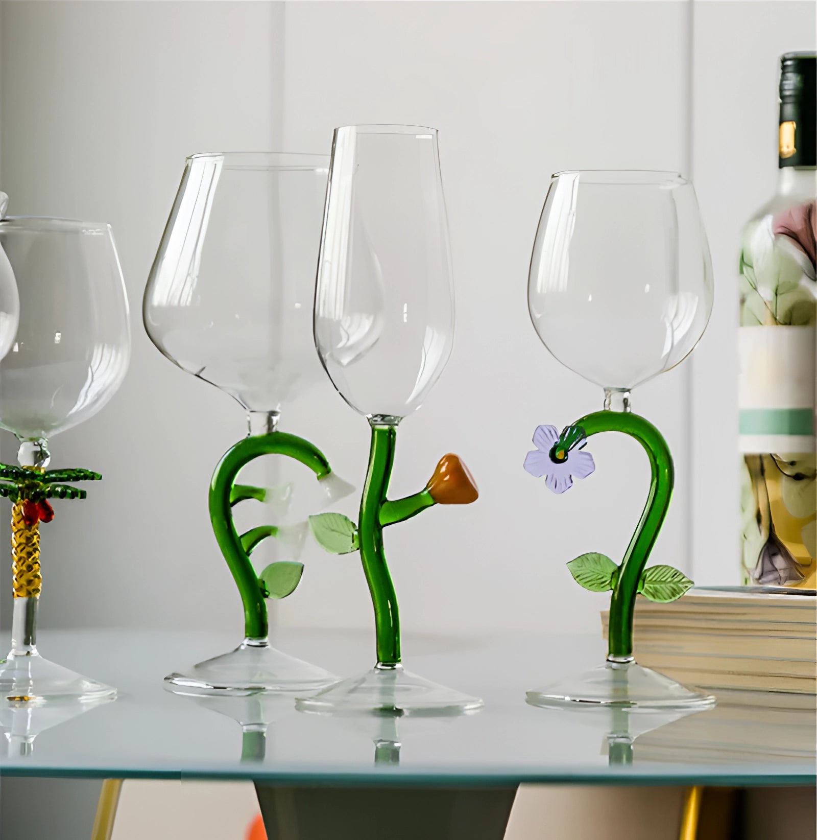 A set of decorative handcrafted vineyard wine glasses filled with white wine, placed on a table with green and yellow accents.