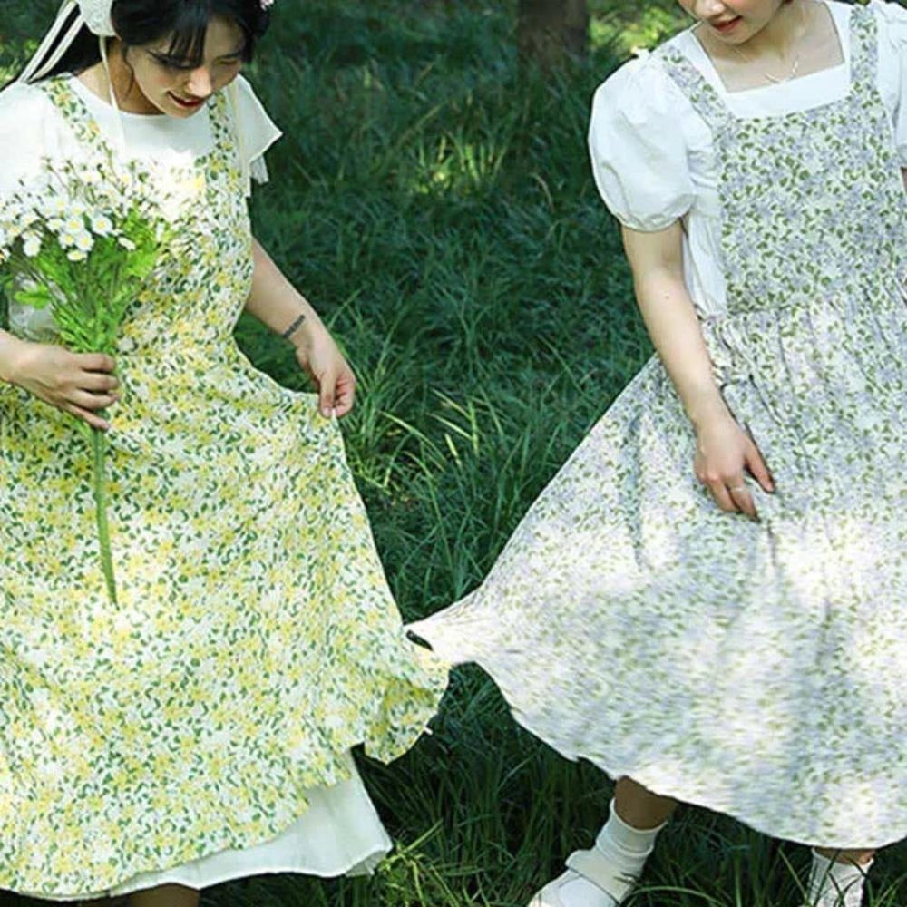 Floral Cotton Apron for Women featuring a vintage design with convenient pockets, shown in a natural setting. The apron is modeled over a white and green dress, highlighting its stylish and practical use in a kitchen environment.