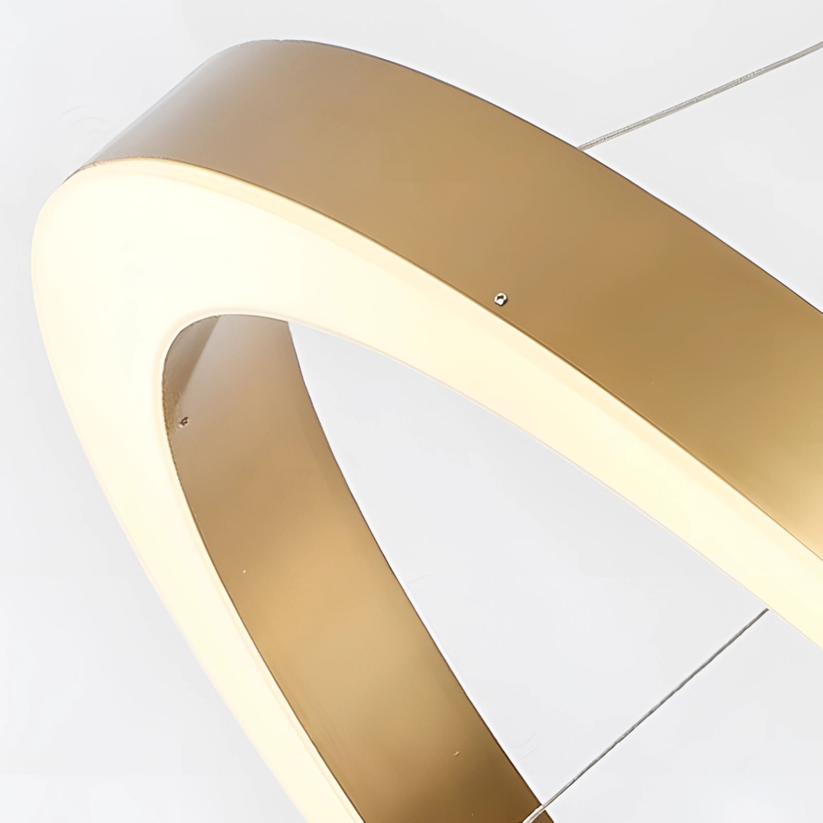 Gold circular LED chandelier with a modern minimalist design, featuring a pendant light fixture hanging from the ceiling, shown in a setting with neutral beige tones.