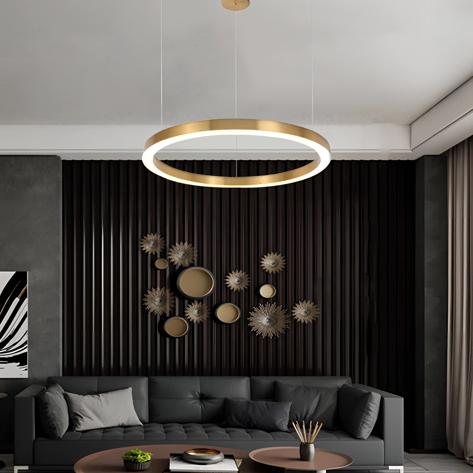Gold circular LED chandelier with a modern minimalist design, hanging in a living room with a white light illumination. The room also features a comfortable couch, a wooden table, and contemporary interior design elements.