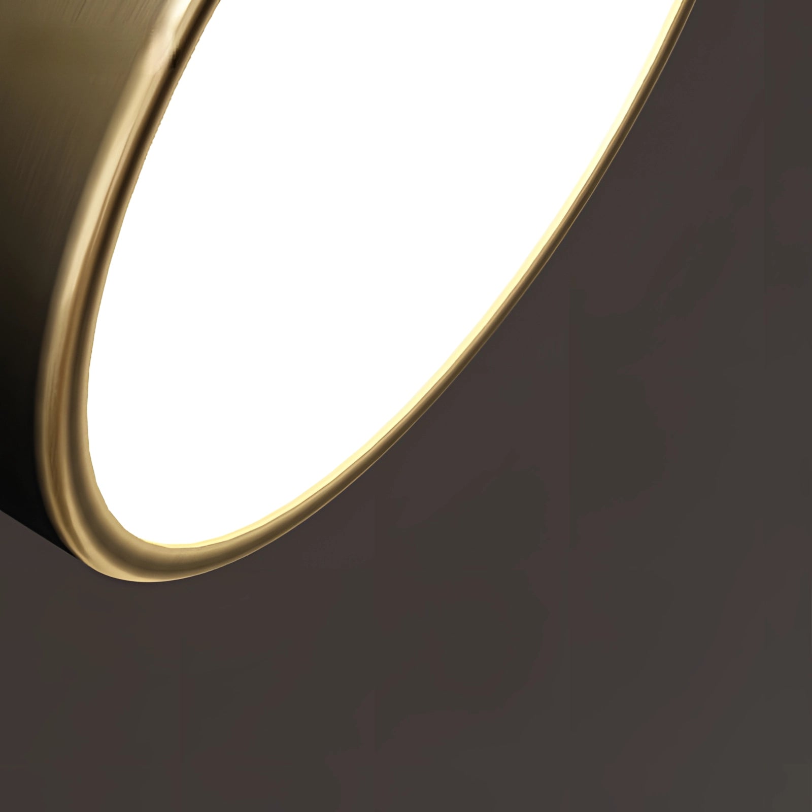 Modern circular gold LED flush mount ceiling light with a minimalist design, featuring a metal frame and shade, mounted on a wooden ceiling.