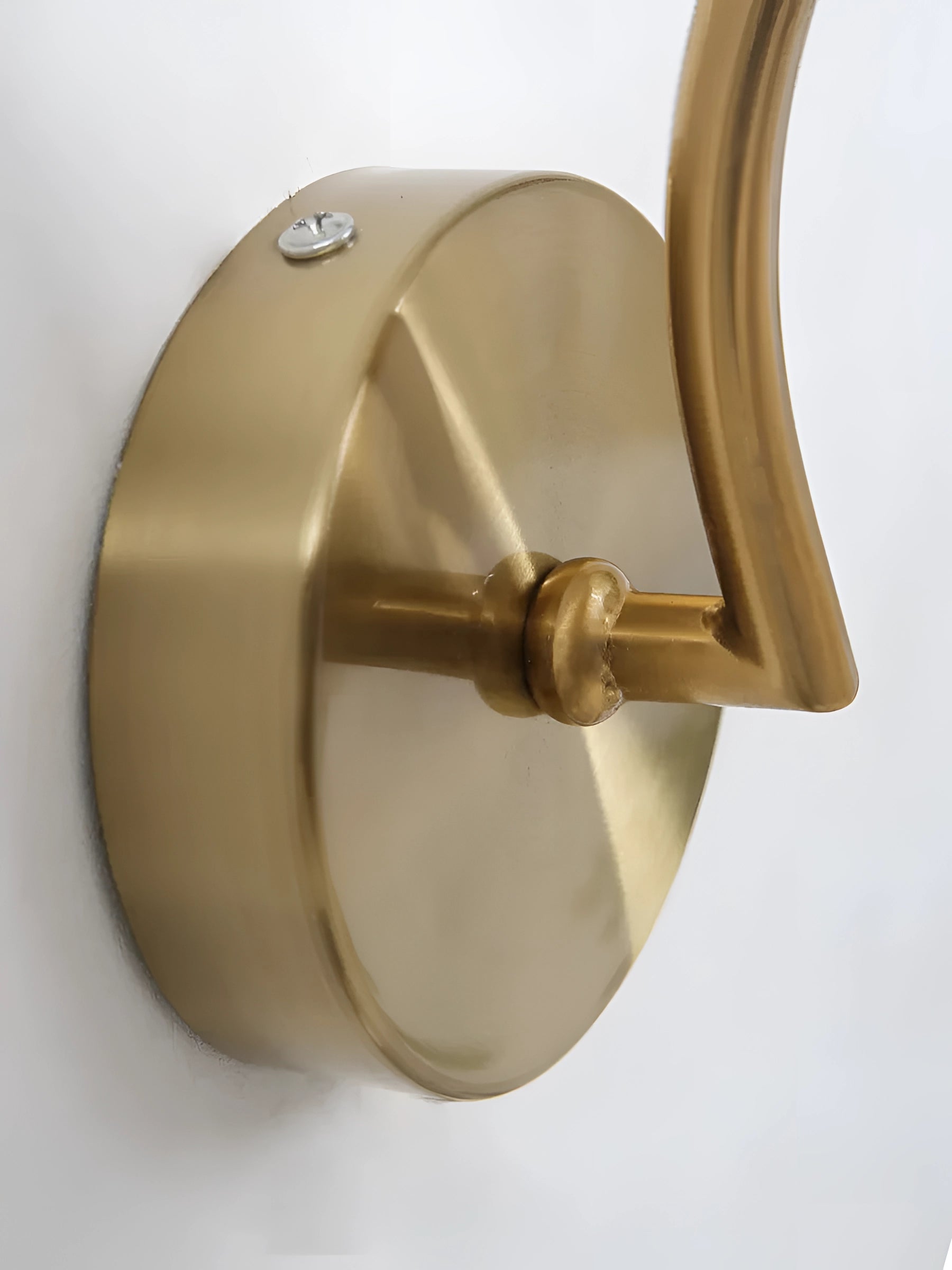 Modern brass wall lamp with ribbed glass globe, gold wall sconce mounted on a wall.