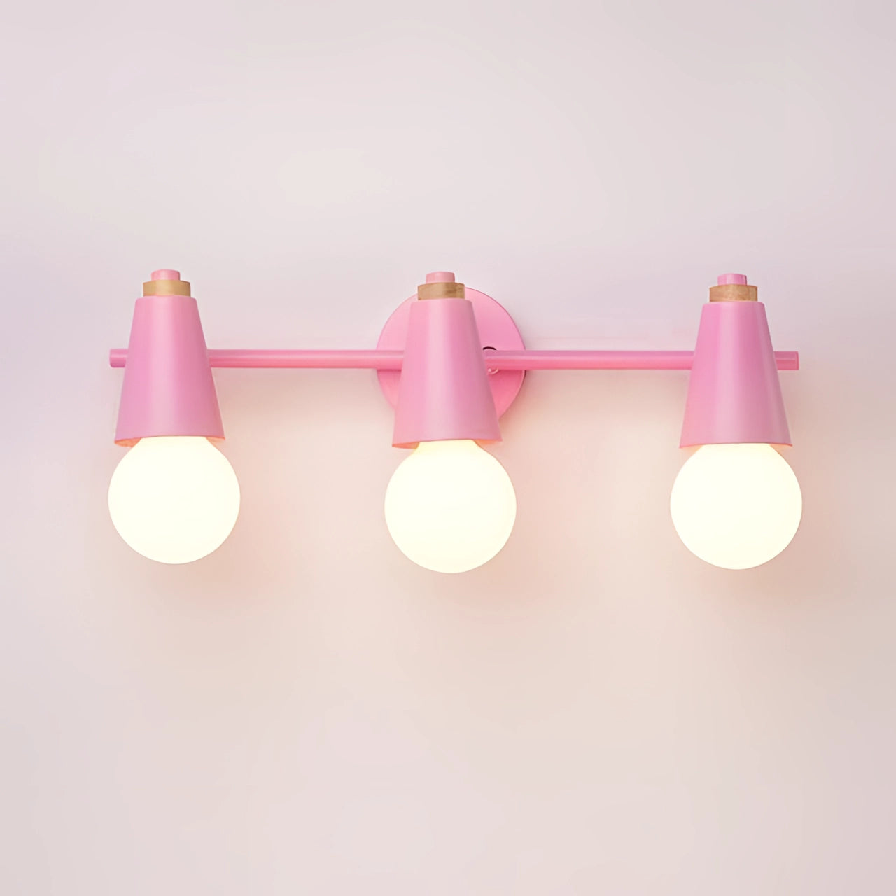 Modern green triple pendant light with three pink cone-shaped lampshades, energy-efficient Scandinavian design, hanging from the ceiling.