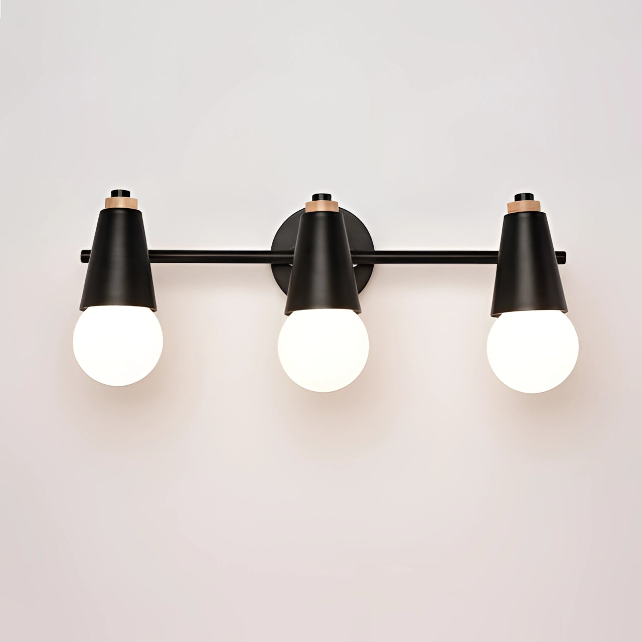 Modern energy-efficient Scandinavian green triple pendant light with three black metal fixtures hanging from a ceiling.