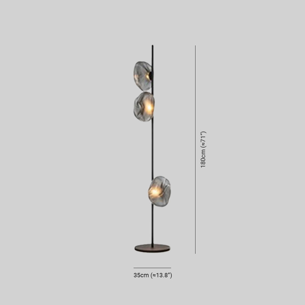 Industrial metallic pebble floor lamp with a sculptural design, featuring a circular metal base and a sleek light fixture.