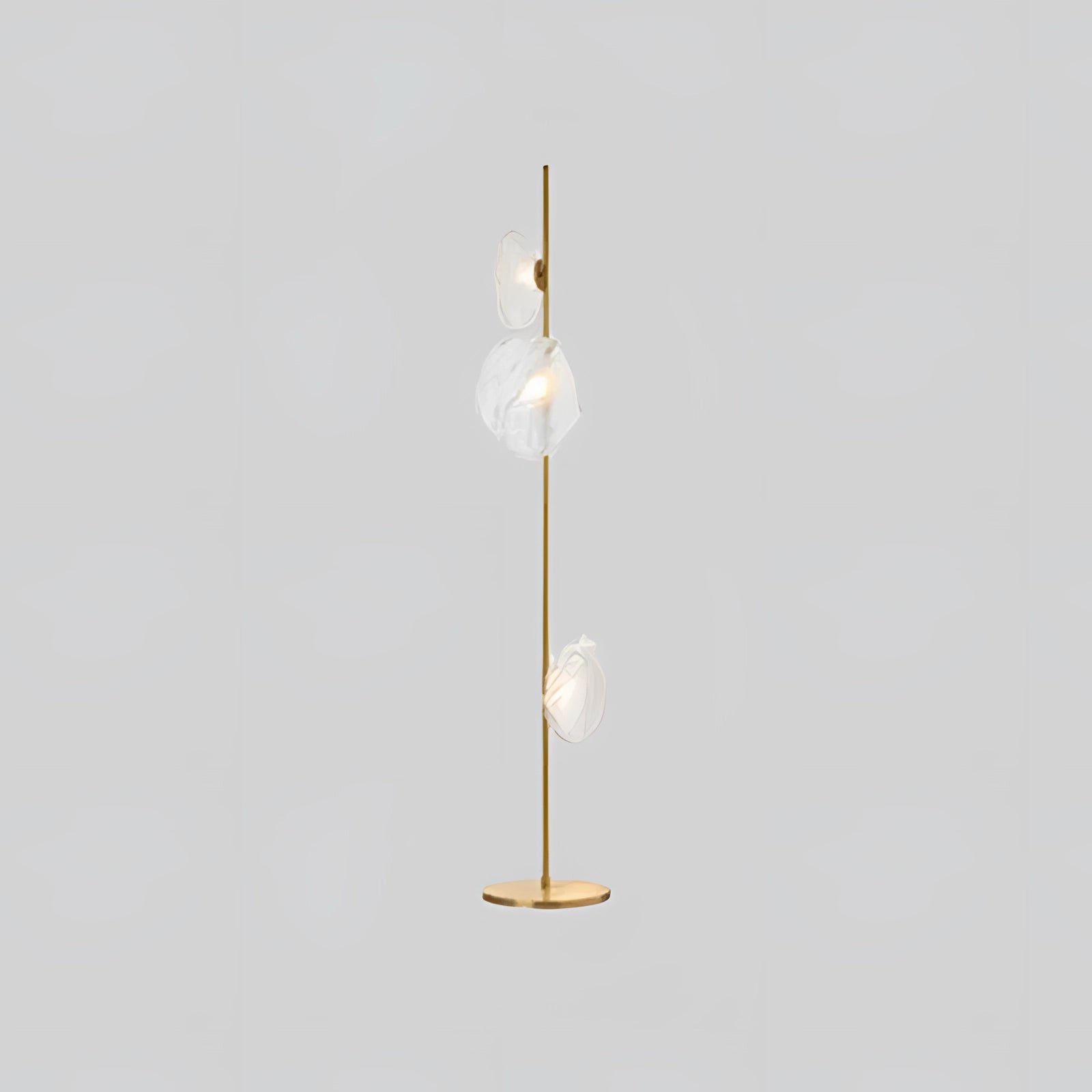 Industrial metallic pebble floor lamp with three sculptural heads in gold and transparent finish, featuring a modern design with circular elements, and multiple light bulbs for enhanced illumination.