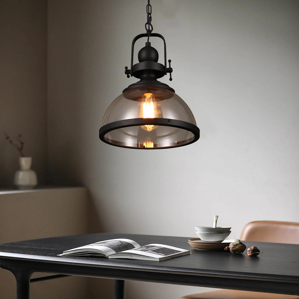 Industrial pendant lights with rustic Edison bulb chandelier hanging above a wooden table, inside a stylishly designed interior space with large windows and minimal tableware.