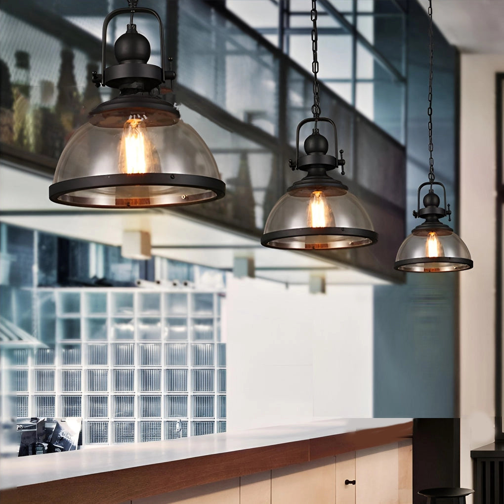 Industrial pendant lights with rustic Edison bulb chandelier design, featured in an interior setting with wood beams, windows, and cabinetry, providing warm, ambient lighting.