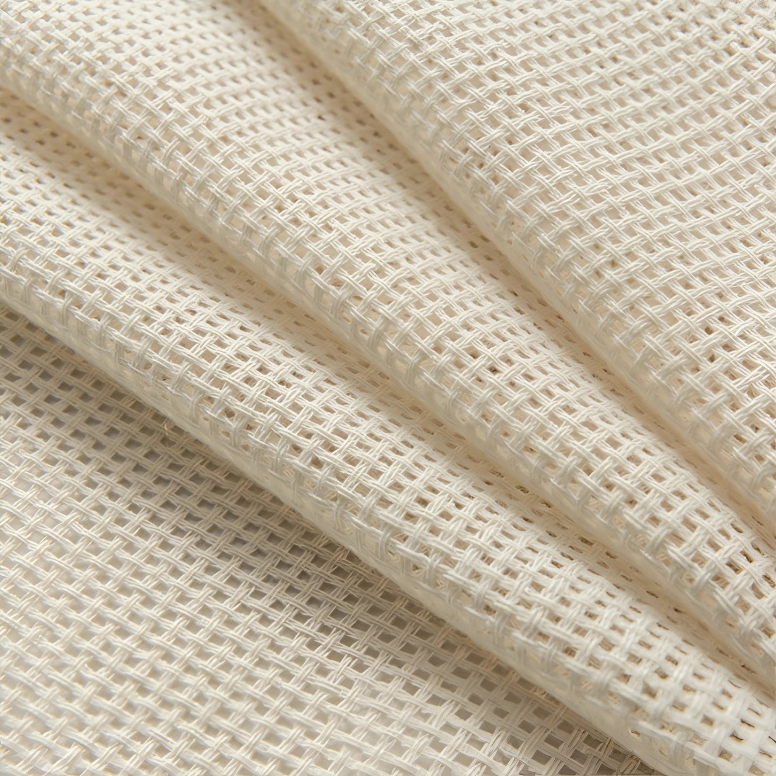 Ivory sheer curtains hanging in a living room setting, featuring elegant linen fabric with a subtle pattern, complemented by a neutral color palette including beige and grey tones, and framed by wooden and metal elements.