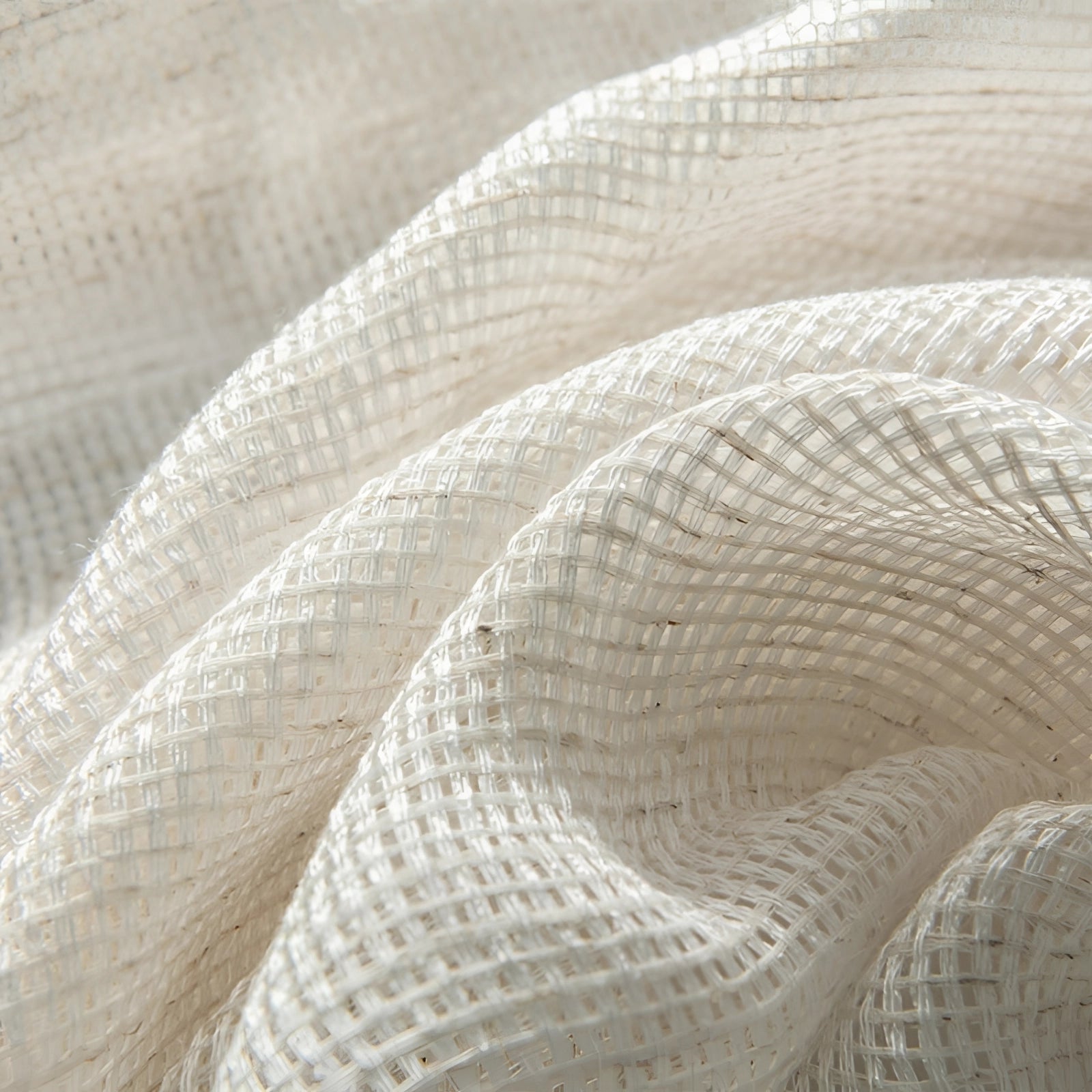 Ivory sheer linen curtains hanging elegantly in a living room setting, draping from a wooden curtain rod against a grey-toned background, complementing the natural and soft interior decor.