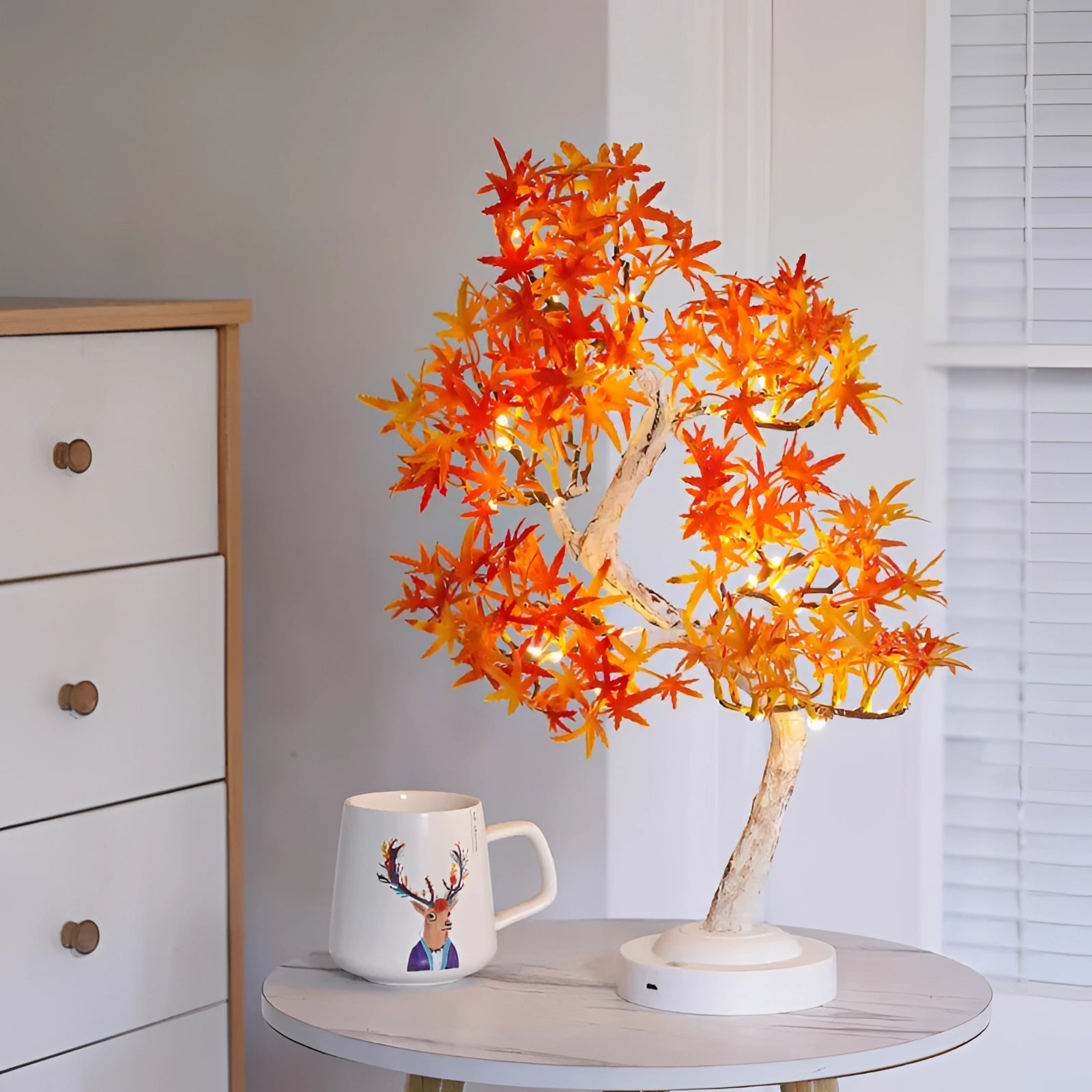 LED Maple Bonsai Tree Lamp with orange autumn leaves, displayed indoors on a surface, emitting a warm light, and connected via USB.