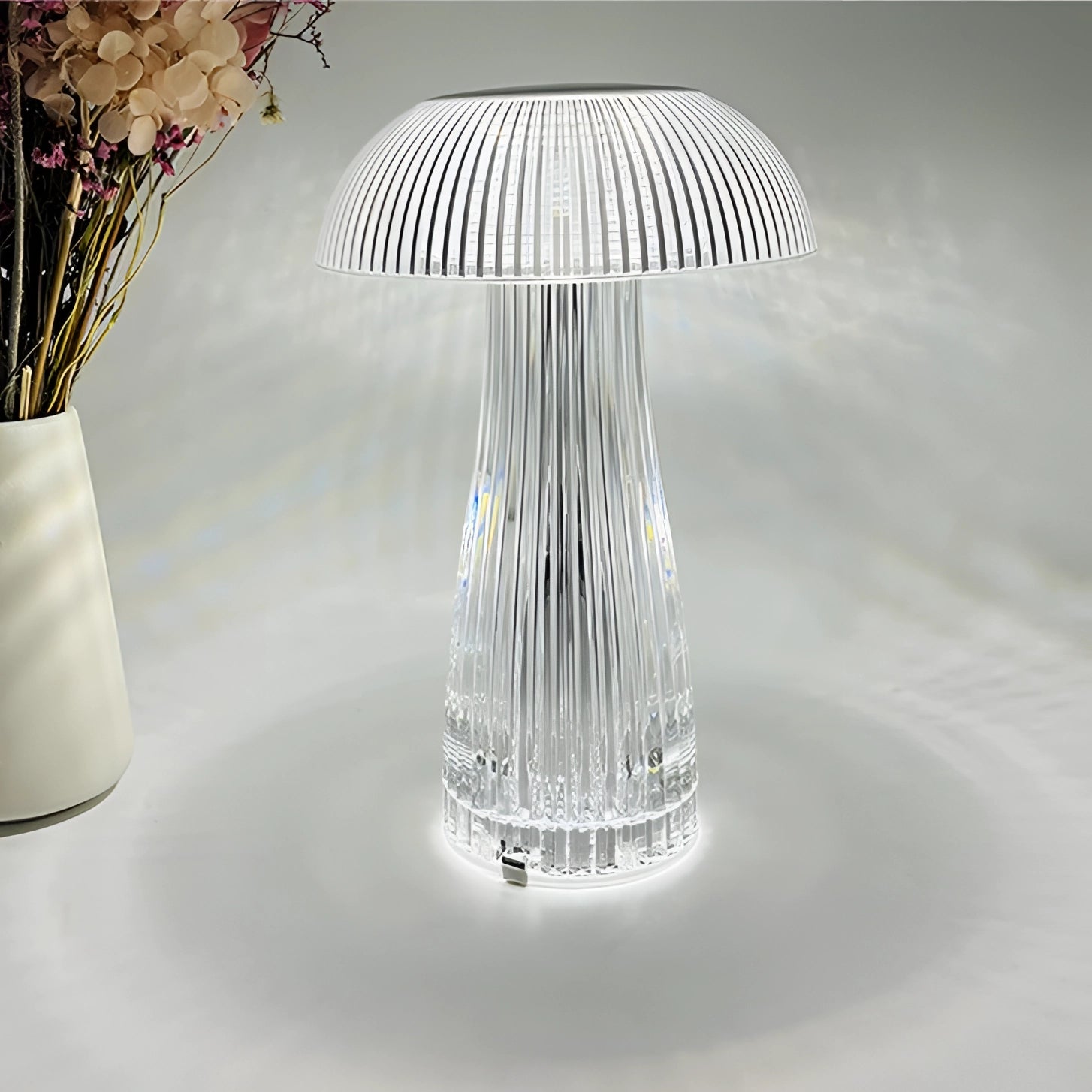 LED Mushroom Table Lamps on a wooden table with decorative glassware and plants in the background.