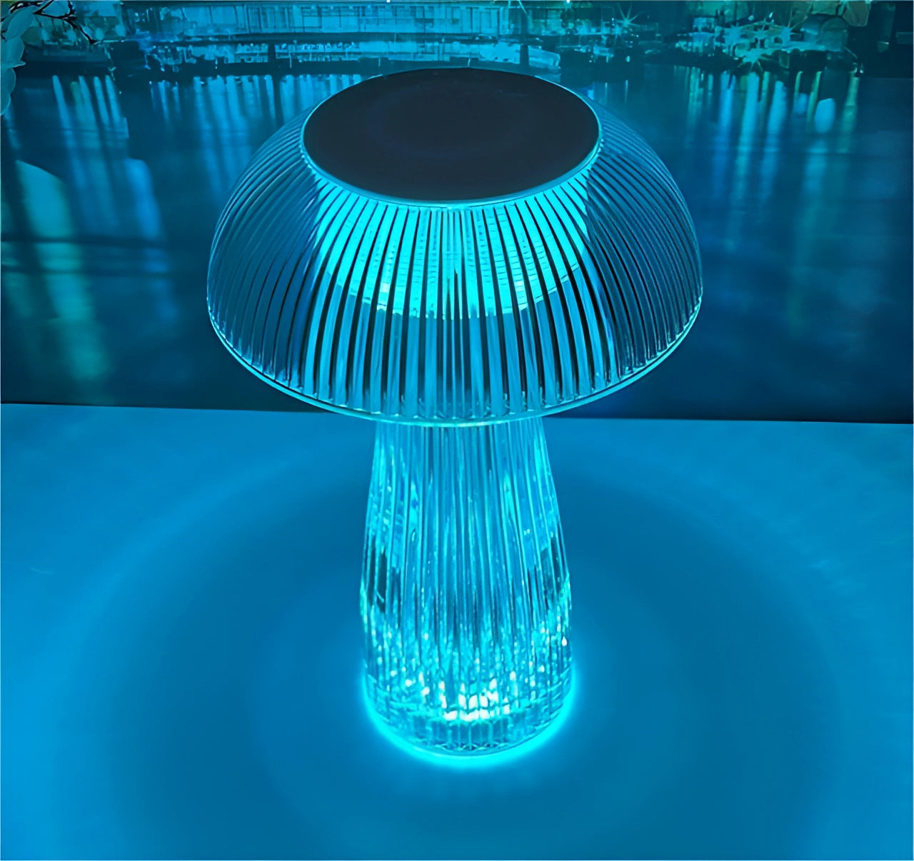 Modern LED mushroom table lamp with a blue, energy-efficient glow on a table.