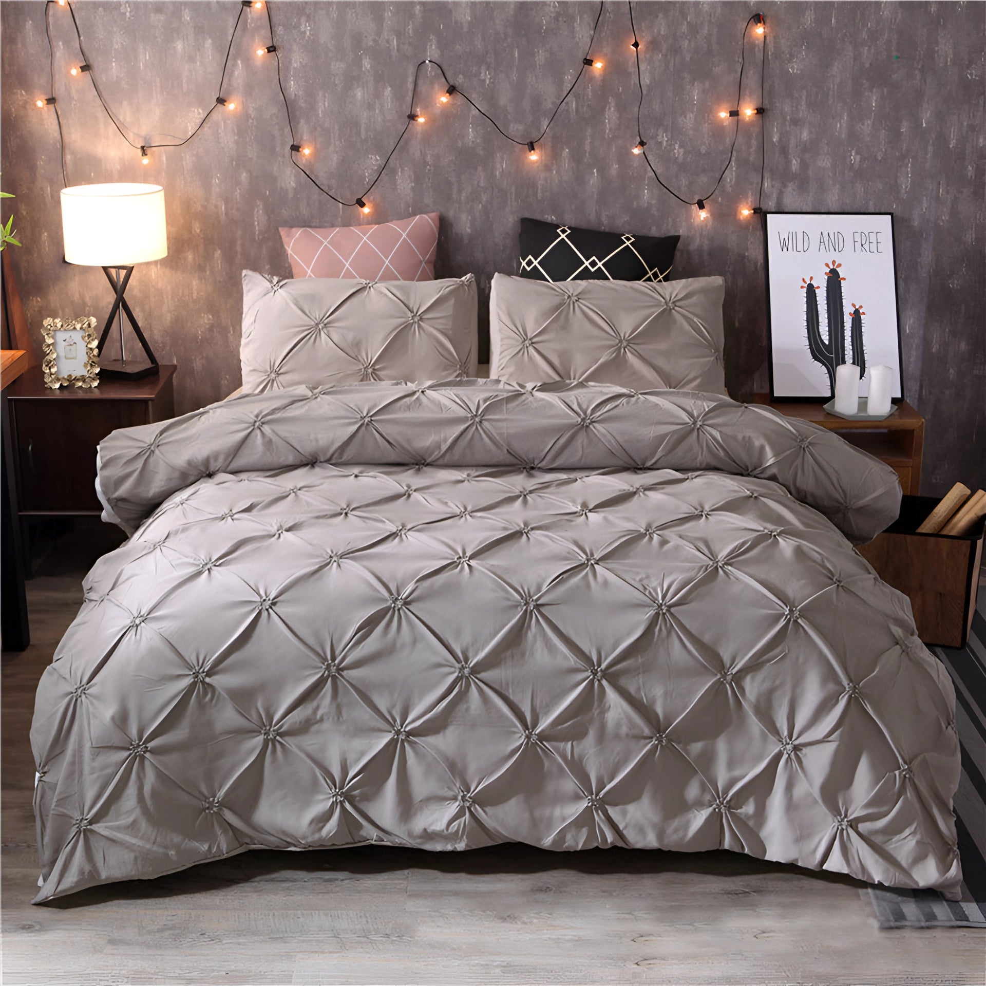 Luxury black pinch pleat comforter in a modern geometric design, displayed on a gray-colored bedframe with elegant interior decor, featuring warm lighting from a bedside lamp.