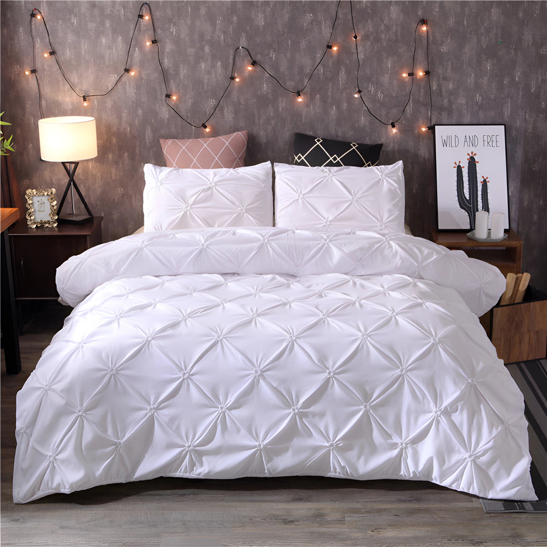 Luxurious white pinch pleat comforter in a modern geometric design displayed on a large bed, complemented by plush pillows and a sturdy bed frame. The setting features warm lighting from a nearby lamp, enhancing the cozy and elegant feel of the bedroom decor.
