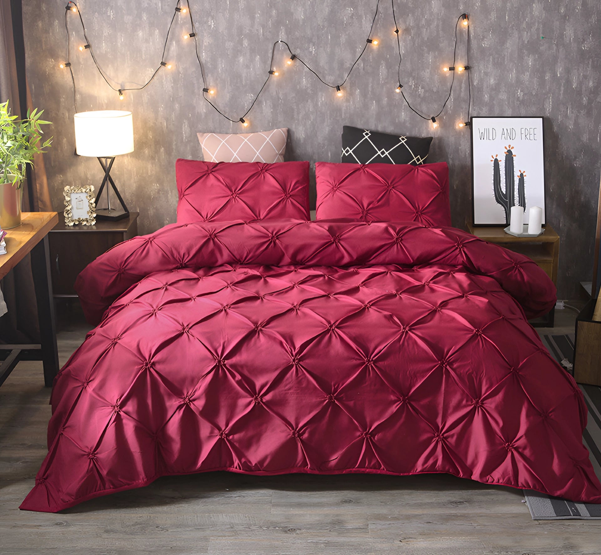 Luxury black pinch pleat comforter in wine red draped over a bed, showcasing a modern geometric design. The comforter complements the elegant interior decor, with elements like subtle lighting and houseplants adding to the cozy atmosphere.