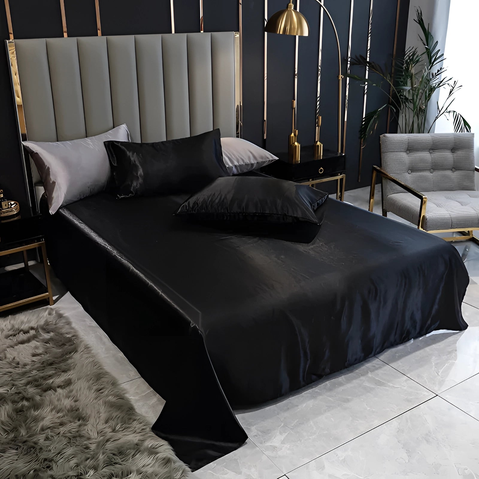 Luxury black silk bedding set with elegant satin bed sheets and duvet cover displayed on a bed in a stylish interior setting, featuring a sleek bed frame and grey accents.